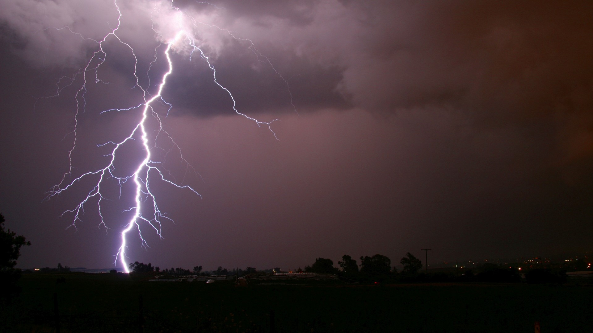 Lightning strike over a dark landscape HD Wallpaper
