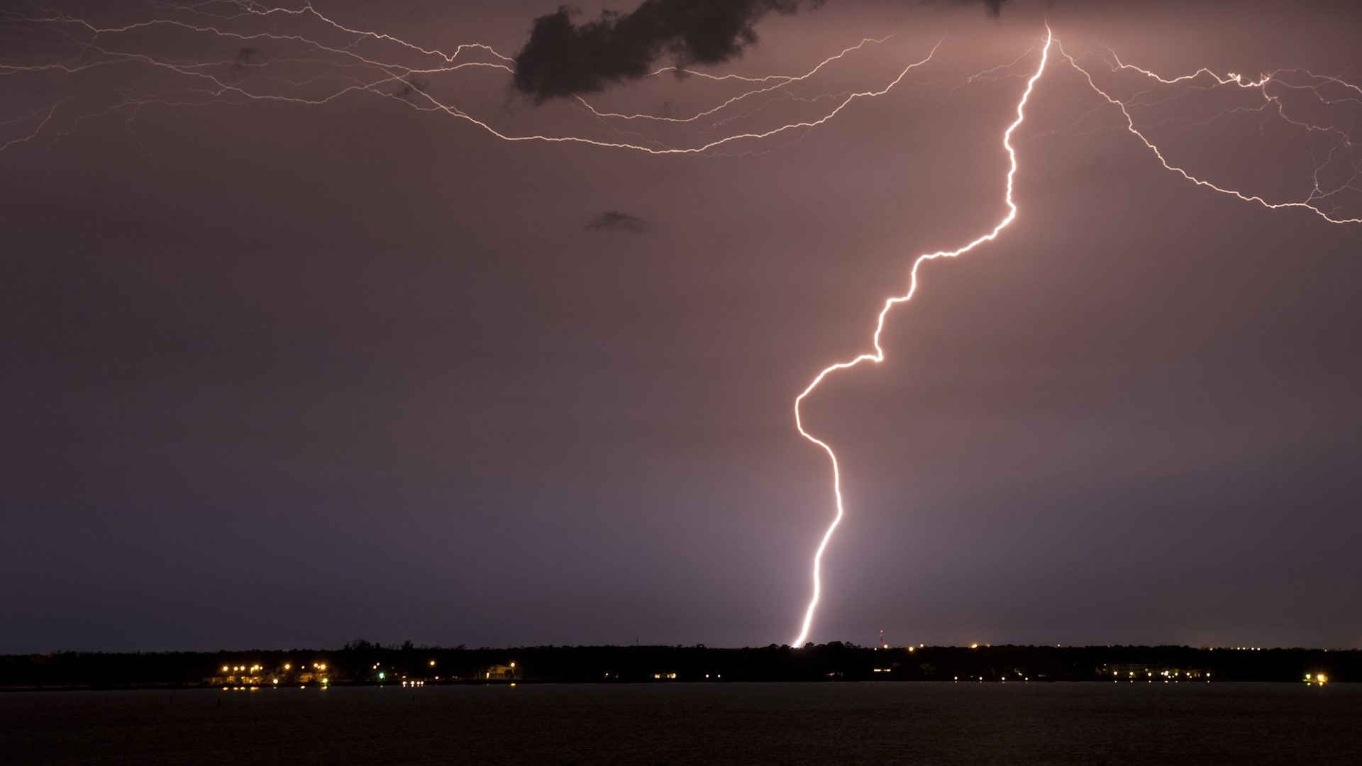 Lightning strike over a dark landscape at night HD Wallpaper