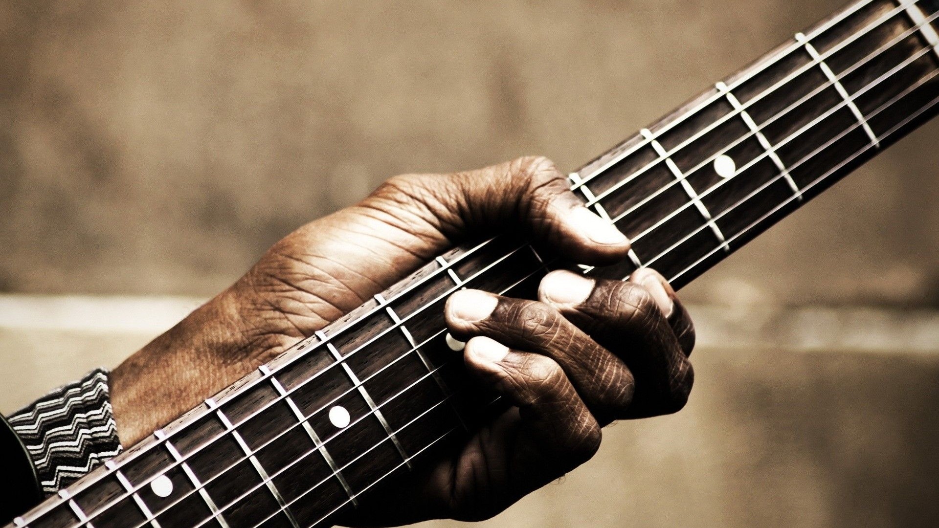 Close-up of a hand playing a guitar HD Wallpaper