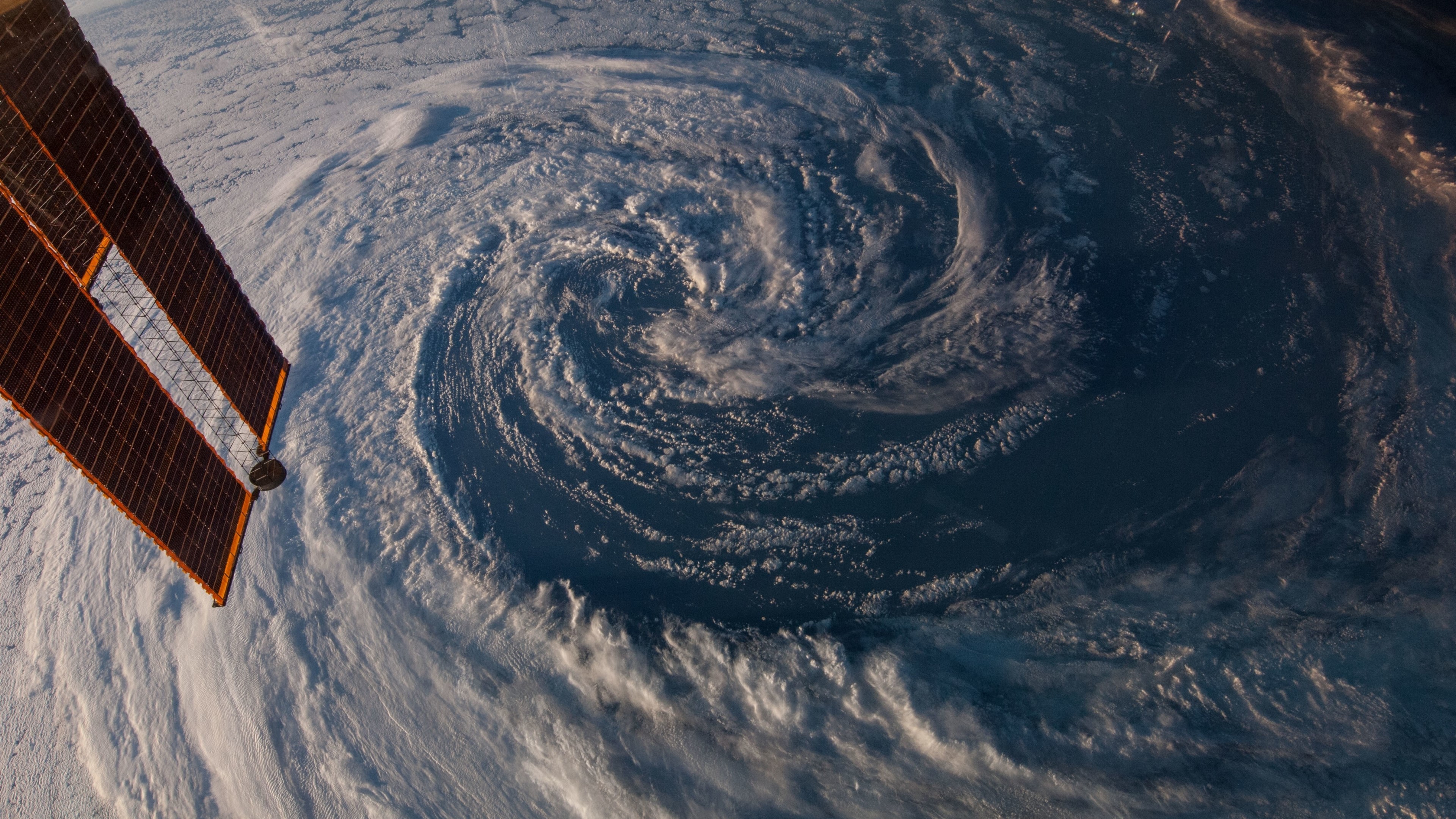 Hurricane viewed from space with solar panels HD Wallpaper