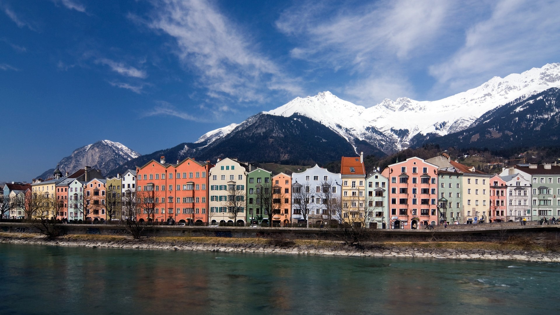 Colorful buildings on the Inn River in Innsbruck with mountains HD Wallpaper