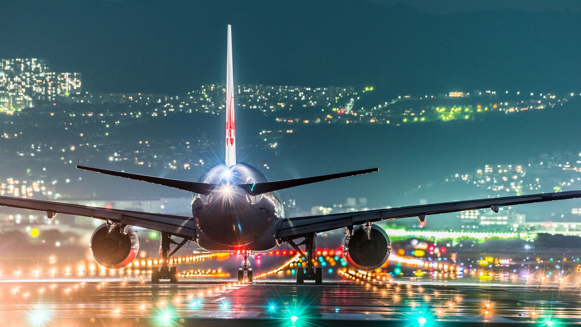Airplane on runway at night with city lights HD Wallpaper