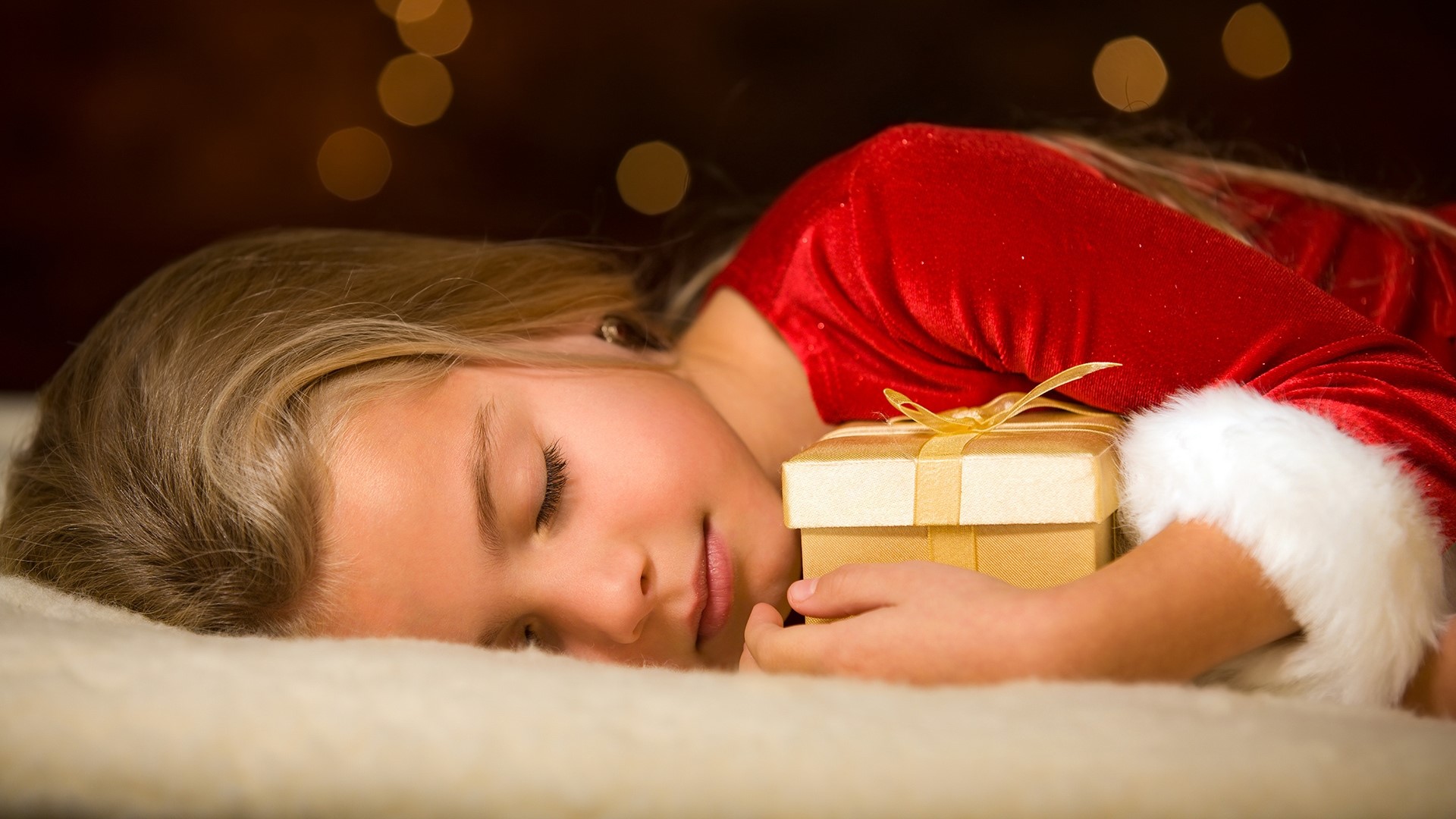 Girl in Santa costume sleeping with gift HD Wallpaper