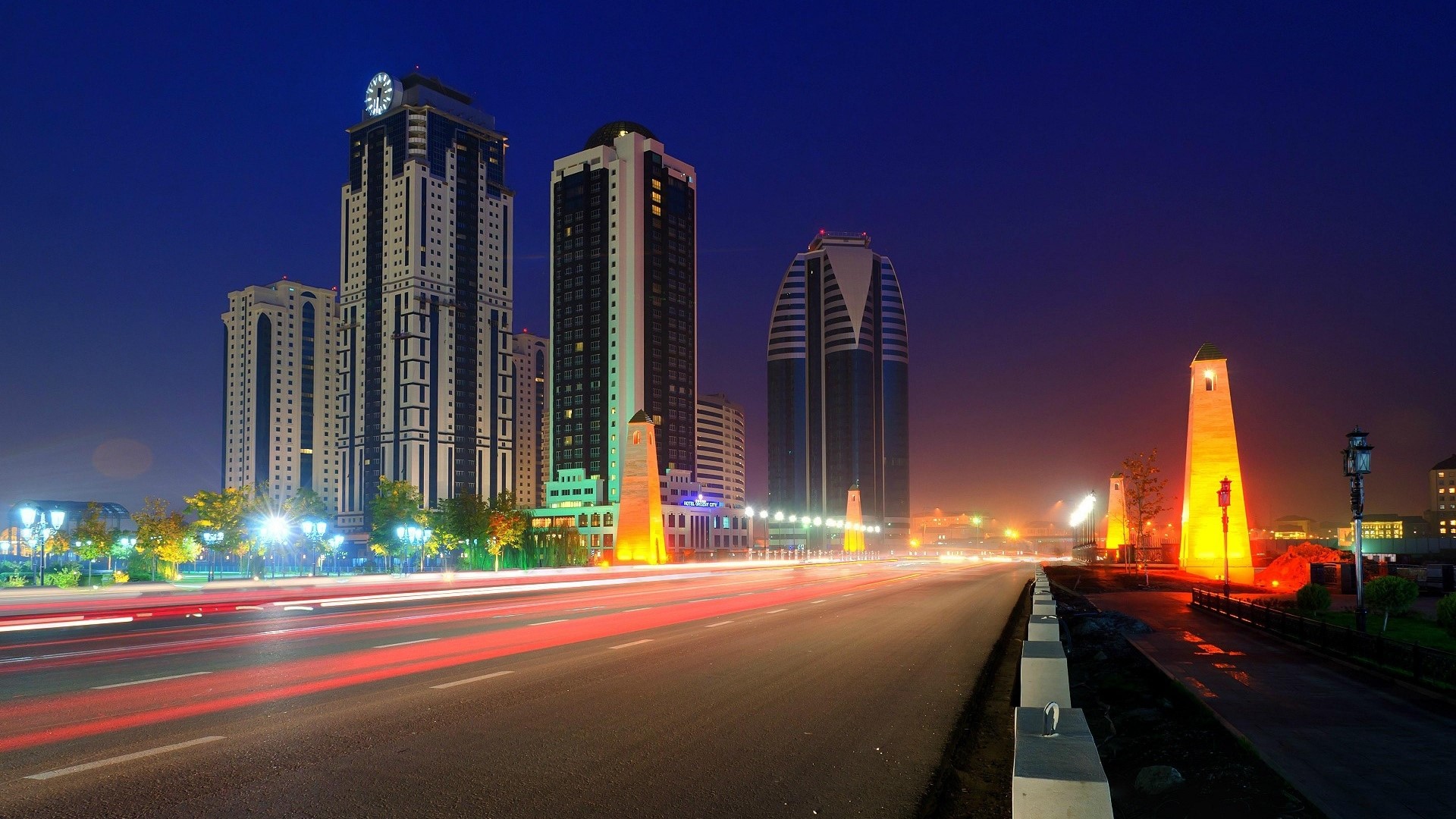 Cityscape with skyscrapers and light trails at night HD Wallpaper
