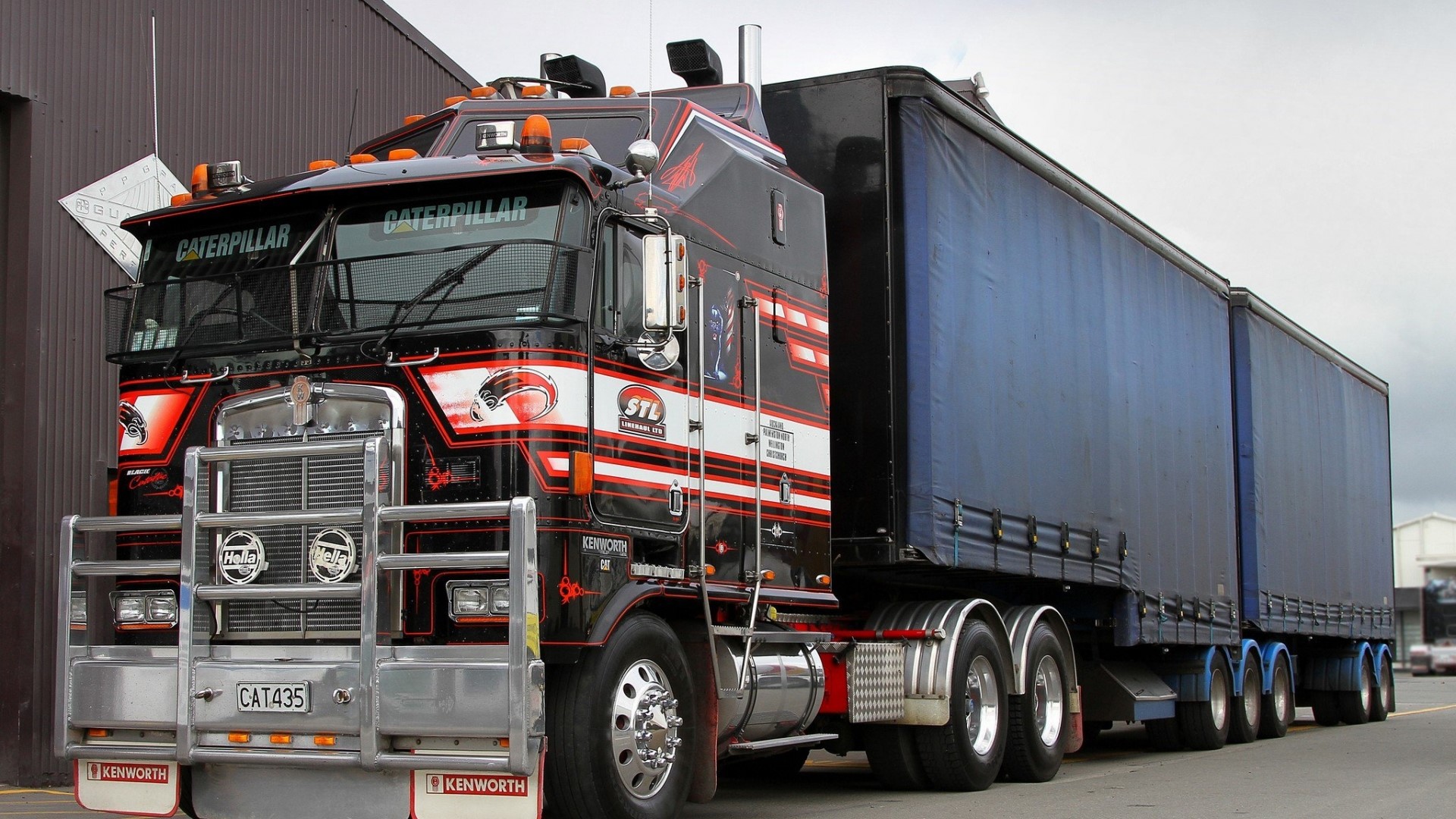 Kenworth truck with Caterpillar branding and blue trailers HD Wallpaper