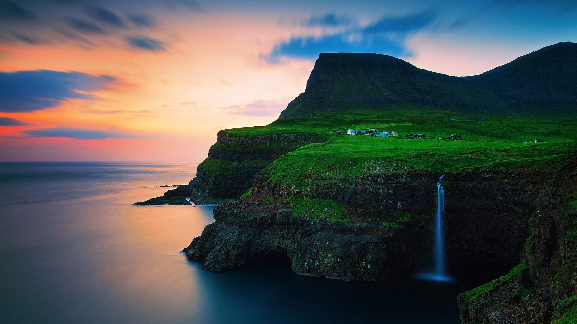 Faroe Islands cliffside village and waterfall at sunset HD Wallpaper