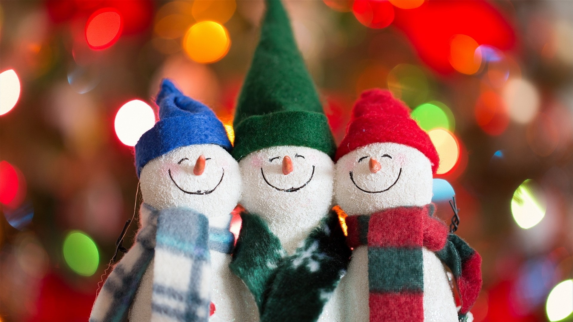 Three happy snowmen with scarves and hats HD Wallpaper