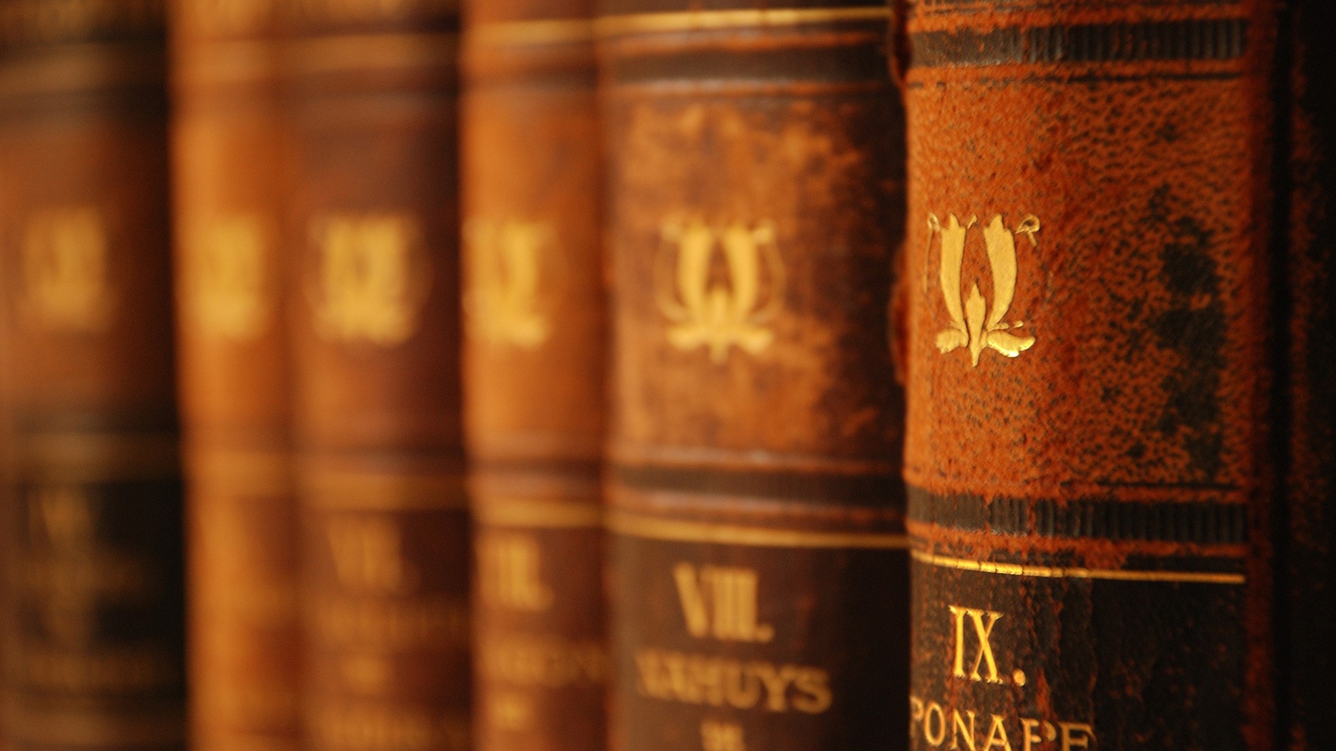 Row of antique leather-bound books HD Wallpaper