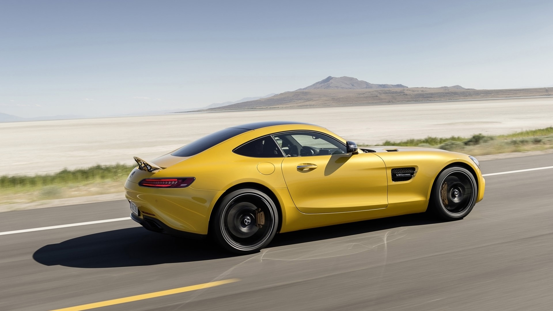 Yellow 2015 Mercedes-AMG GT driving on a road HD Wallpaper
