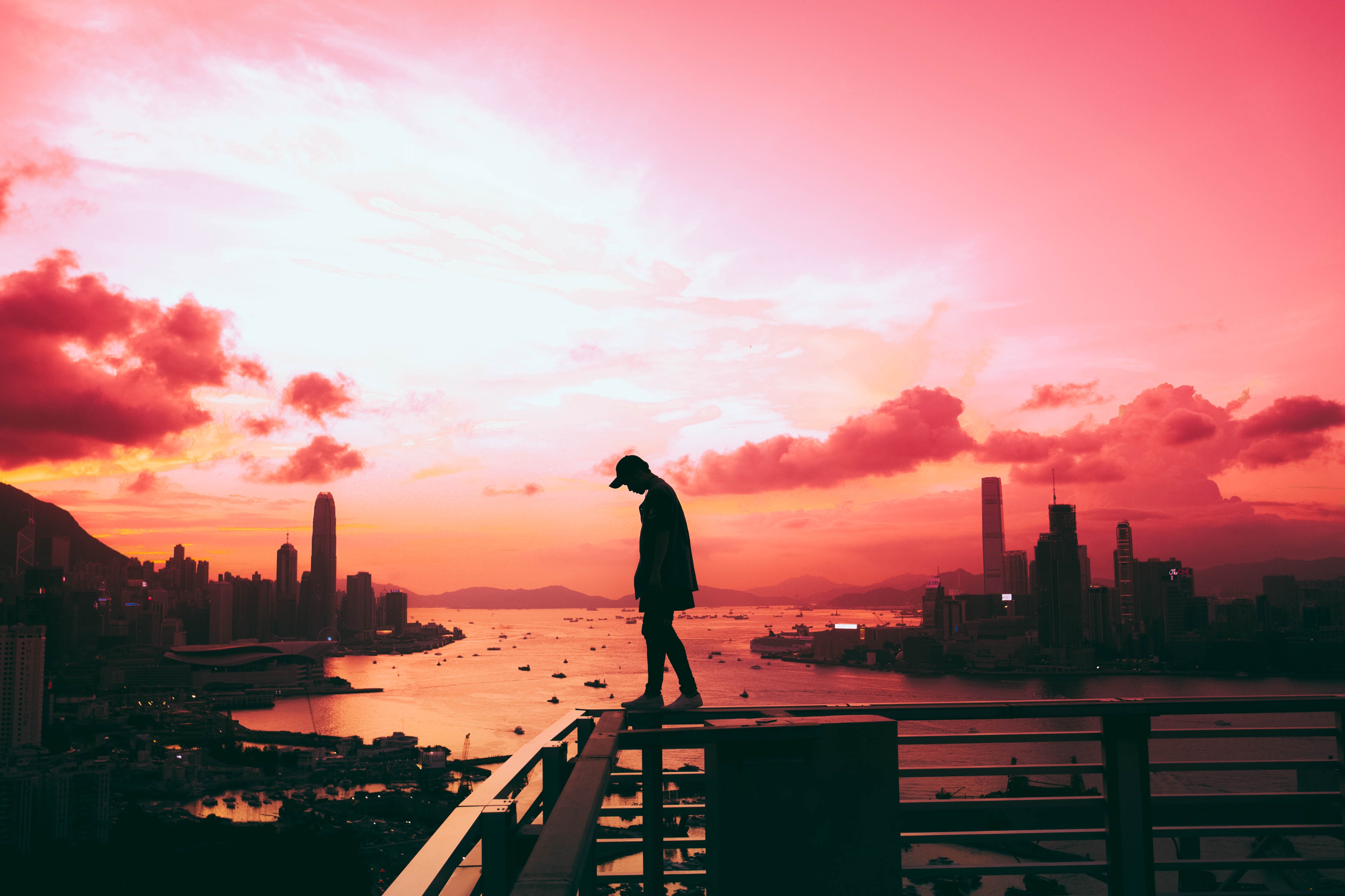 Silhouette of a person on a rooftop at sunset HD Wallpaper