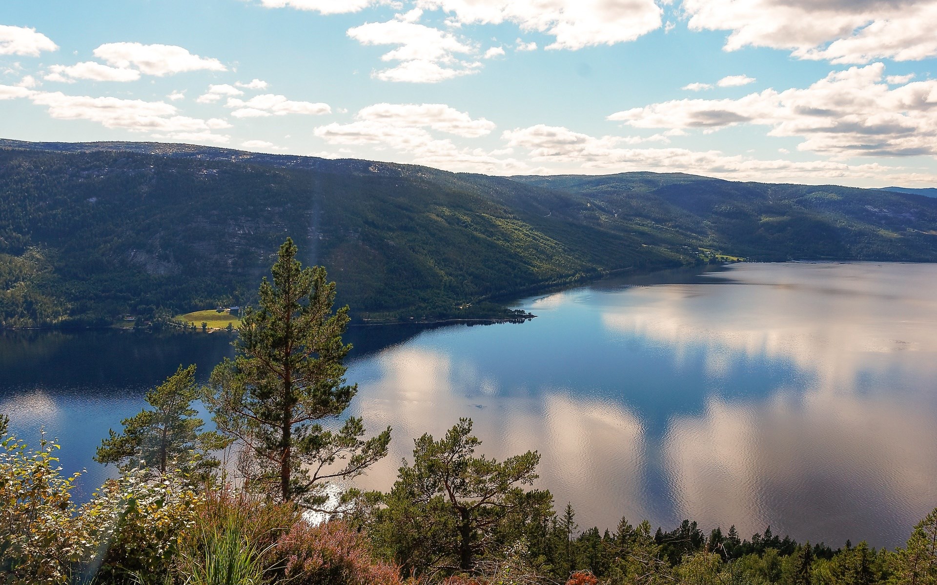 Lake surrounded by forested hills under a cloudy sky HD Wallpaper