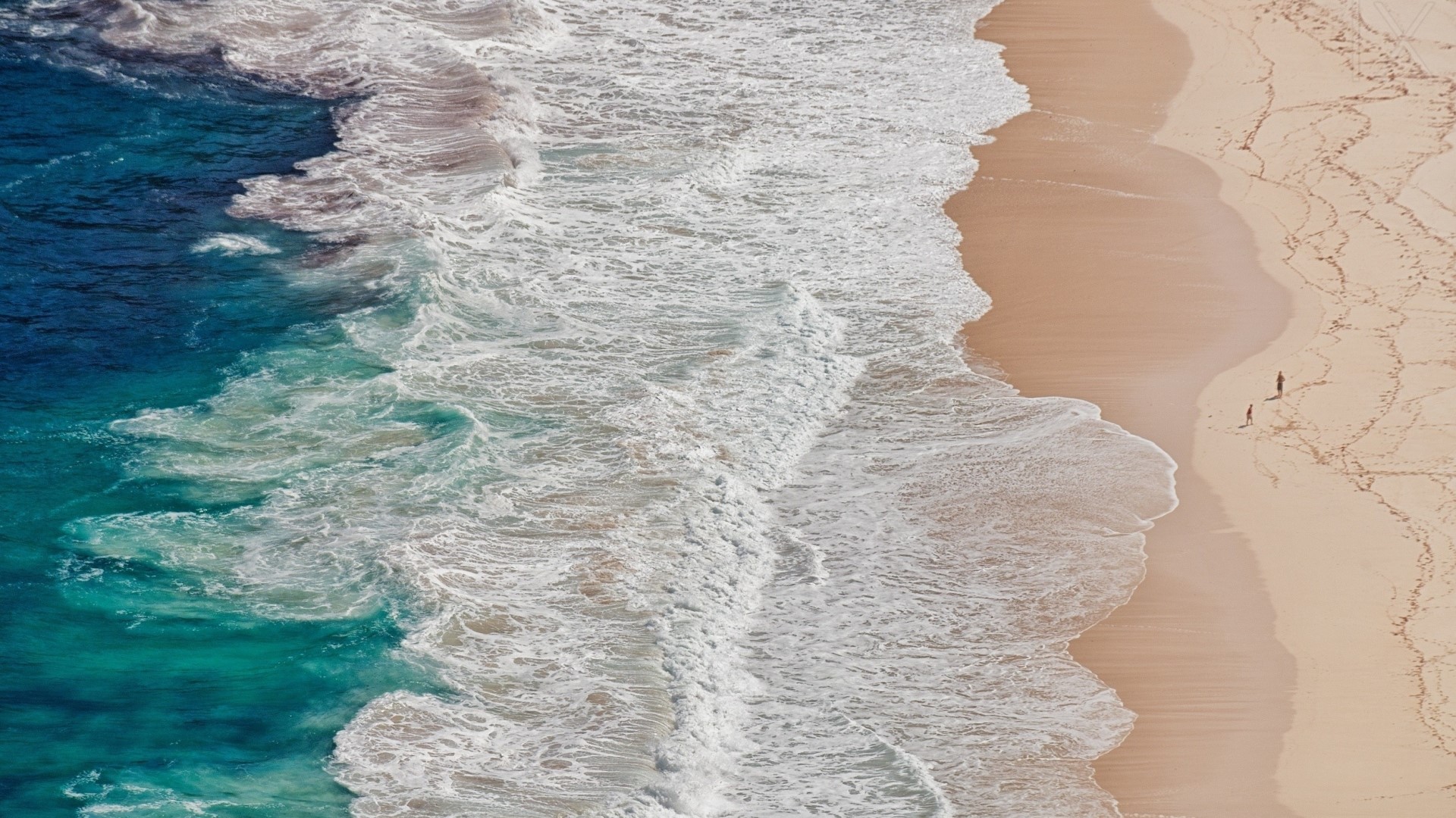 Waves crashing on a sandy beach with two people HD Wallpaper