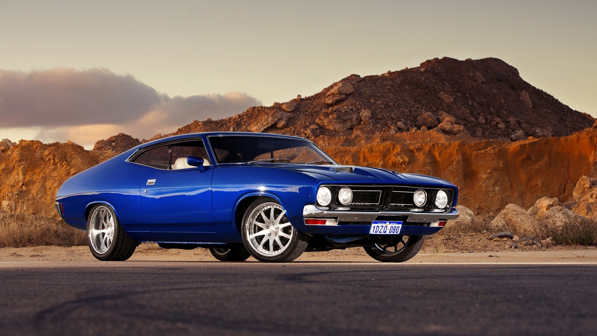Blue Ford Falcon GT in a desert landscape HD Wallpaper