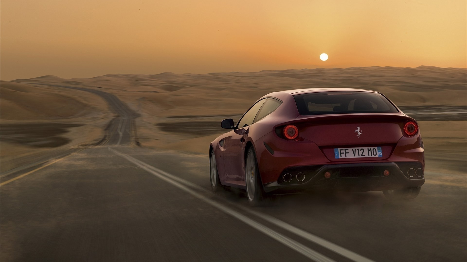 Ferrari driving on a desert road at sunset HD Wallpaper
