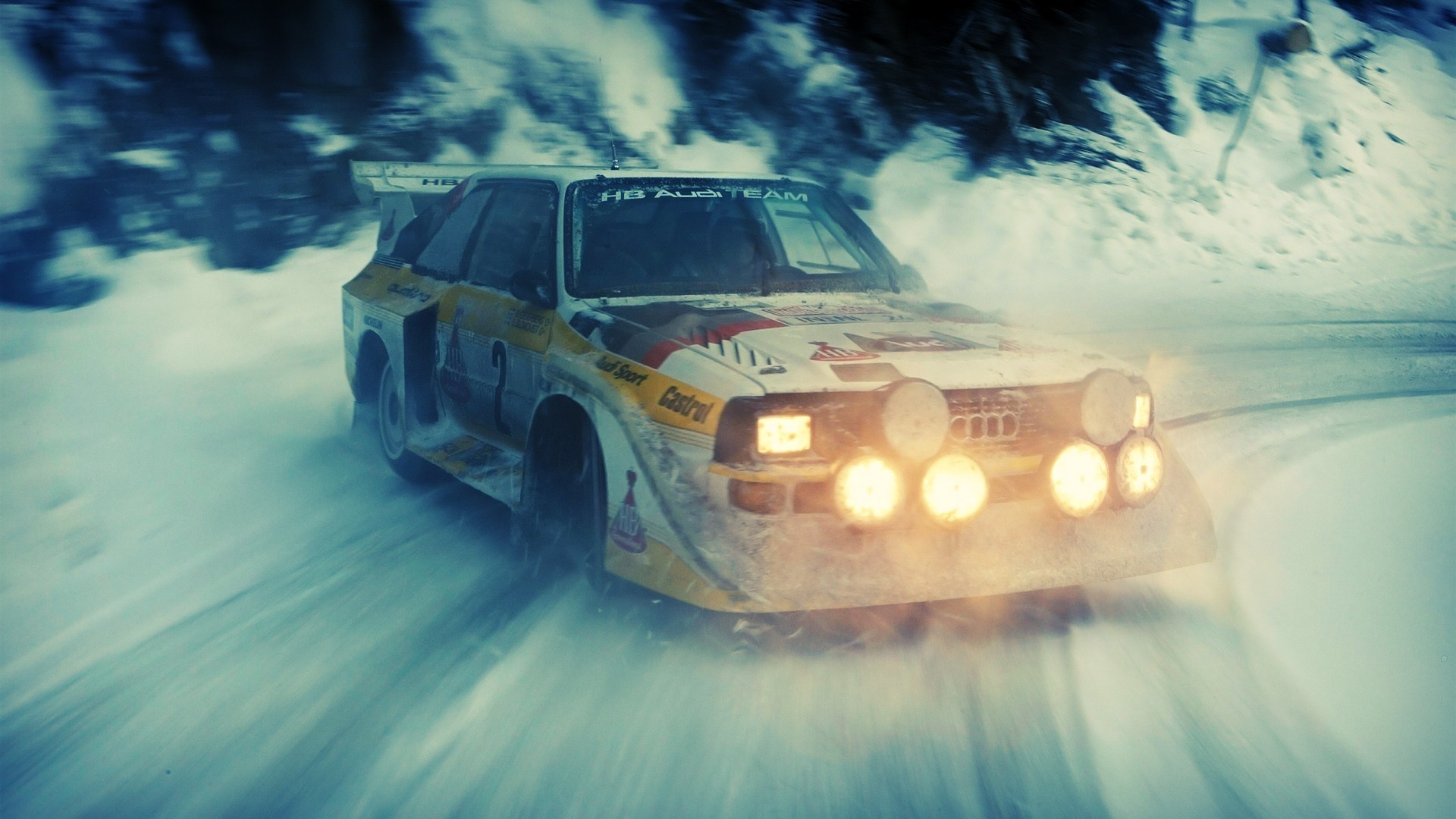 Audi Quattro rally car drifting on a snowy road HD Wallpaper