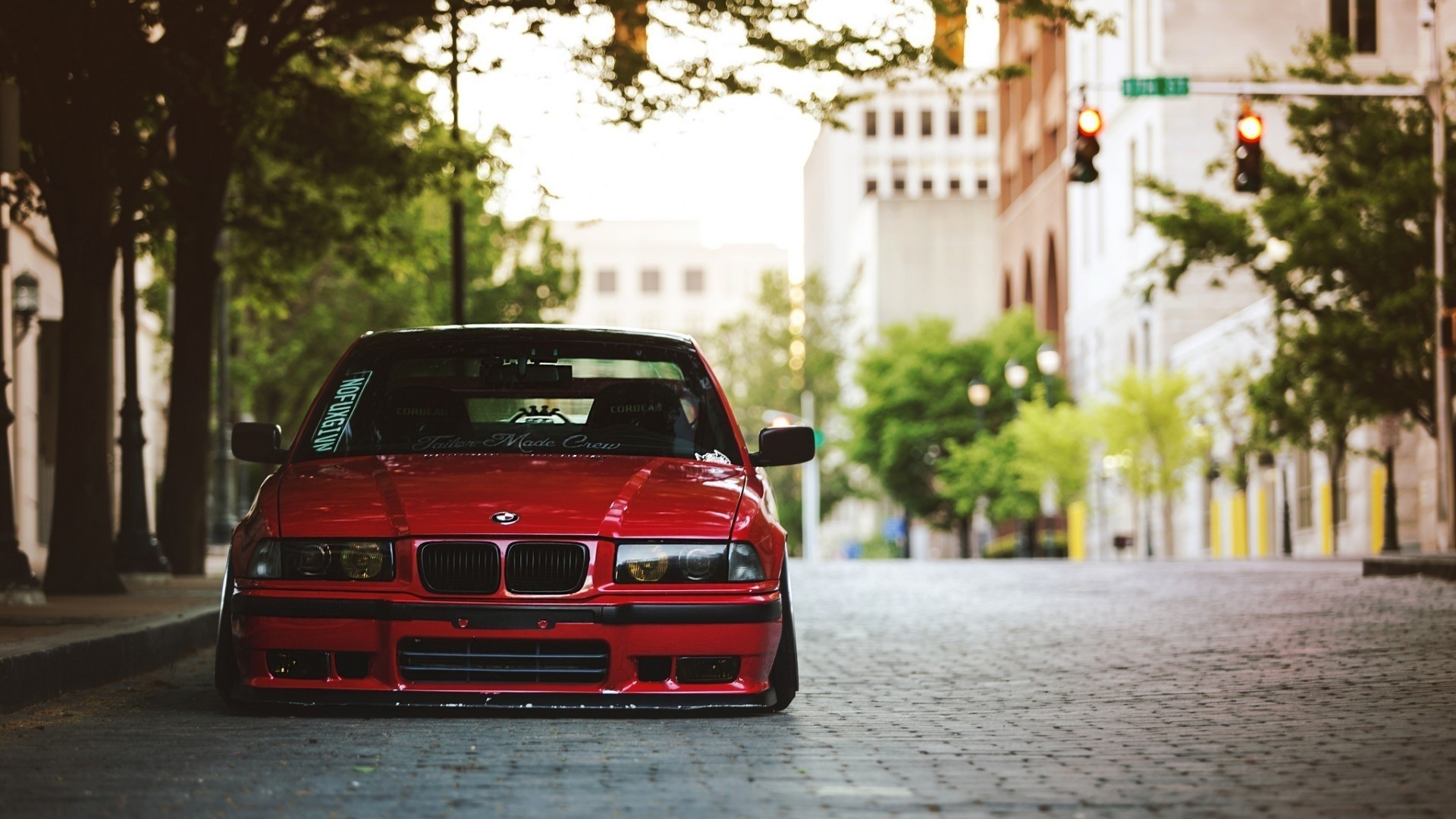 Red BMW E36 on a Cobblestone Street HD Wallpaper