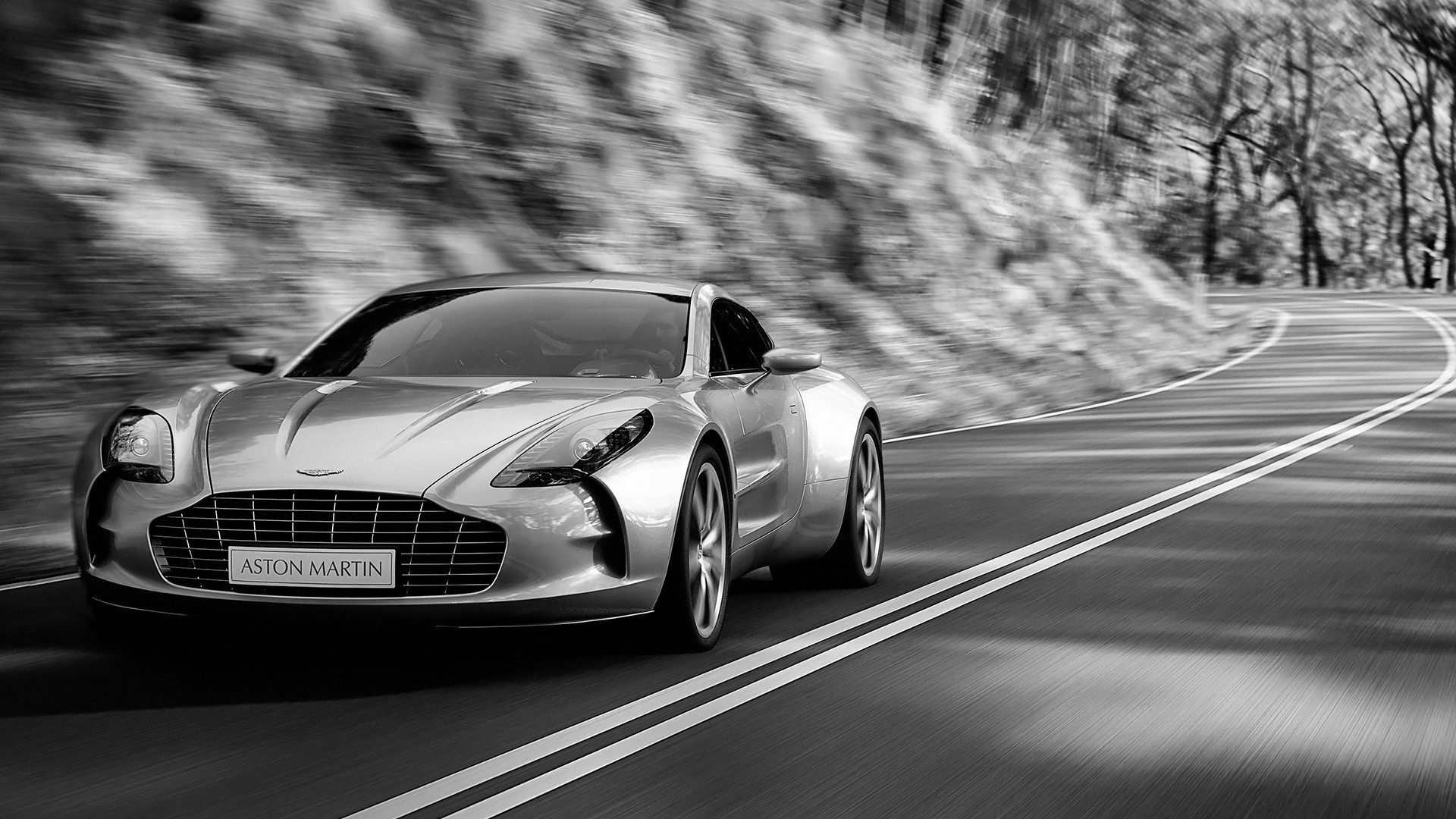 Aston Martin driving on a winding road HD Wallpaper