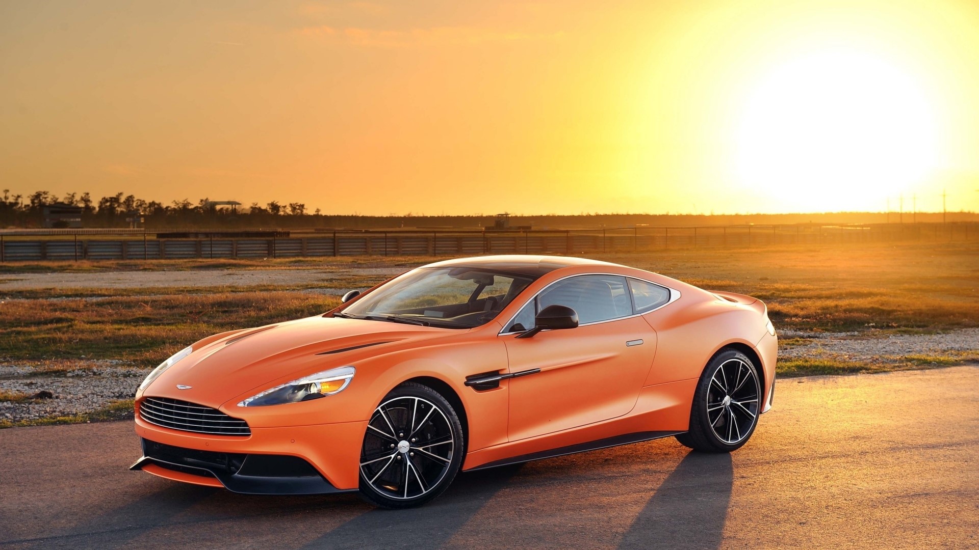 Orange Aston Martin Vanquish on a Racetrack HD Wallpaper