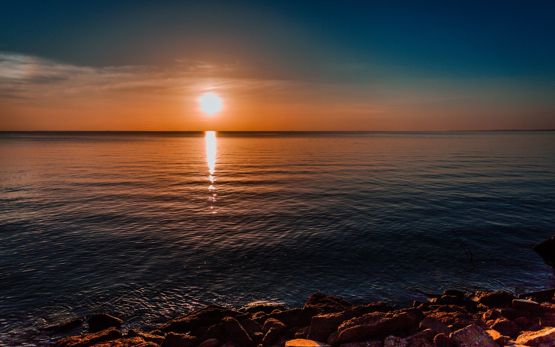 Sunset over the ocean with rocks in foreground HD Wallpaper