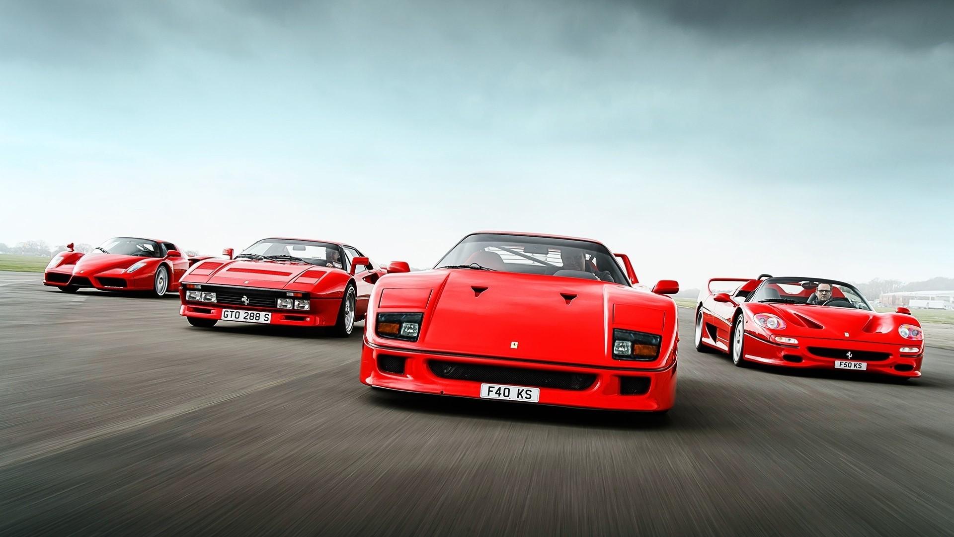 Four Red Ferraris on a Racetrack HD Wallpaper
