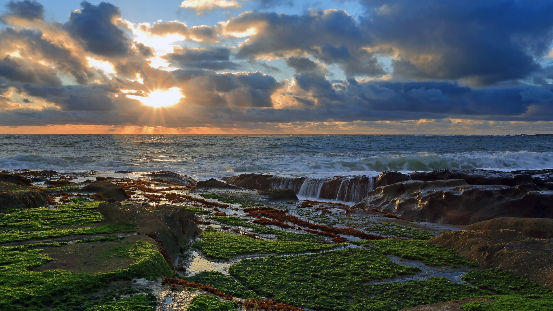 Sunset over rocky coast with green moss HD Wallpaper