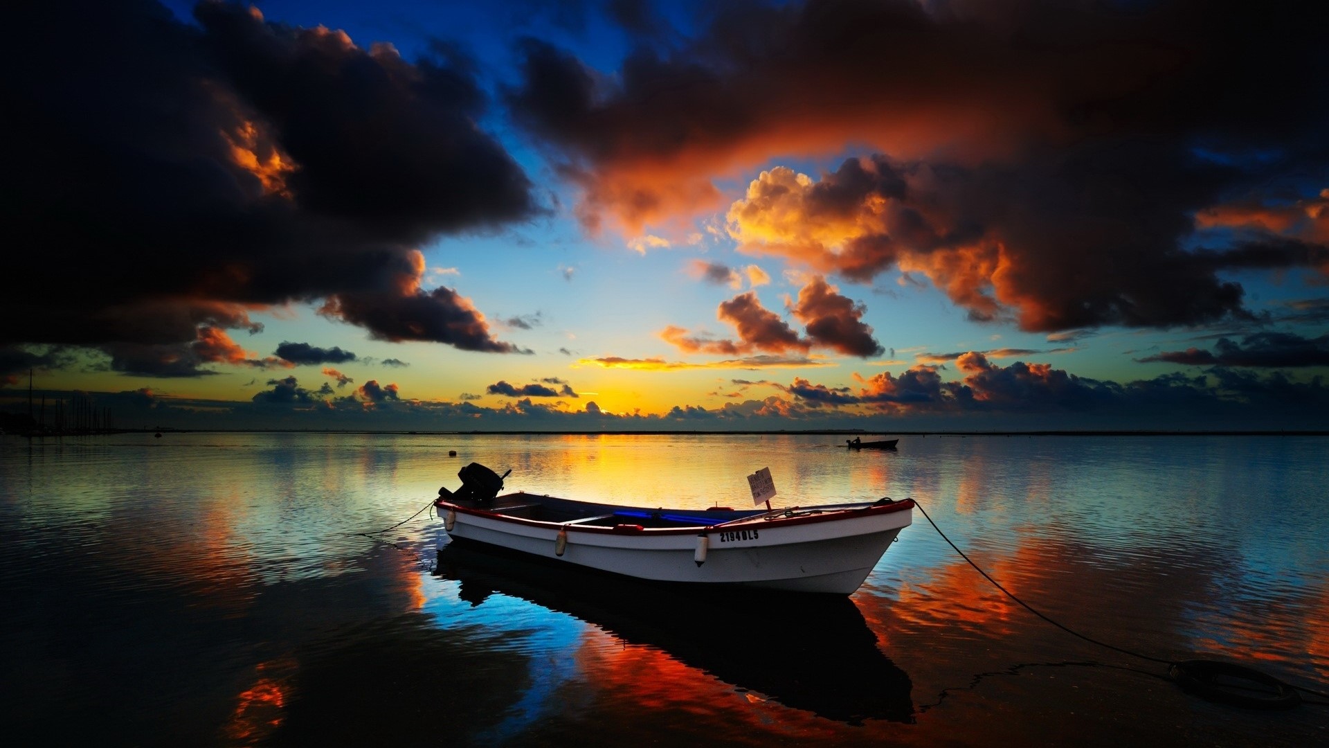 Boat on calm water during sunrise with colorful clouds HD Wallpaper
