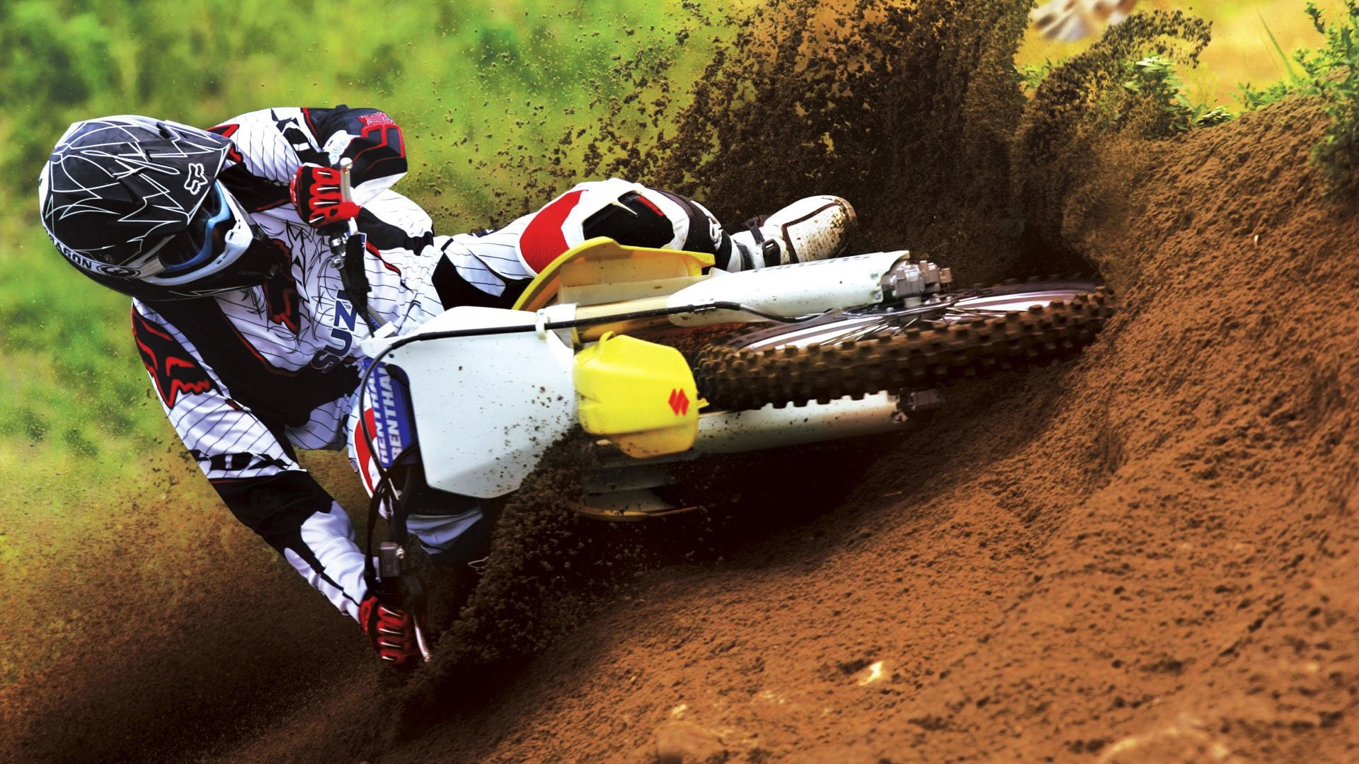Dirt bike rider in action on a Suzuki HD Wallpaper
