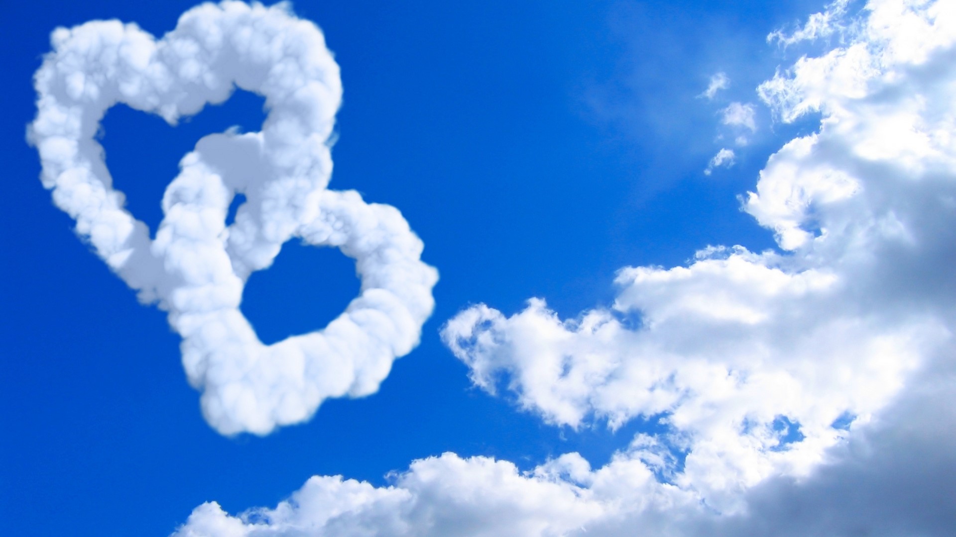 Two Intertwined Heart Clouds in a Blue Sky HD Wallpaper