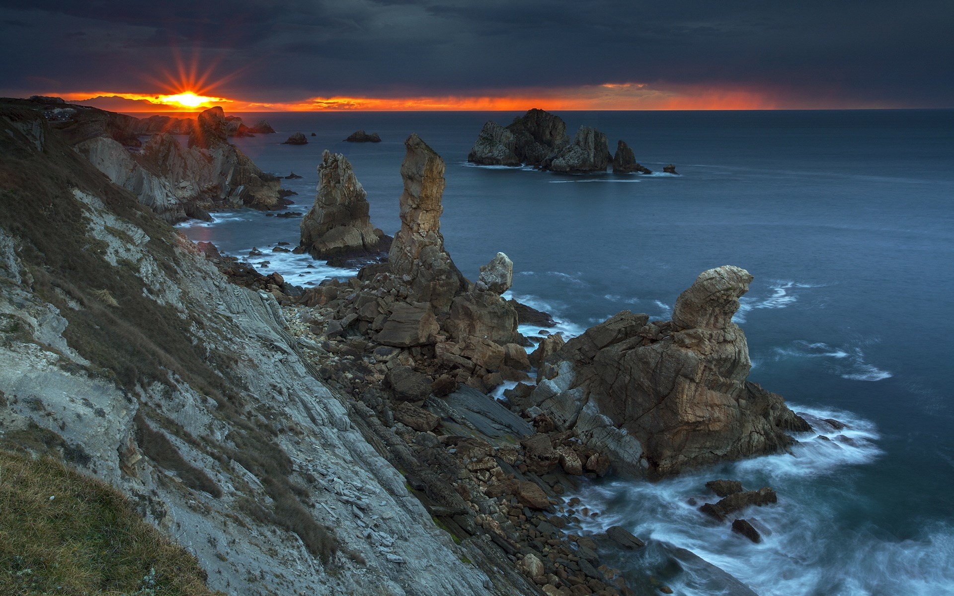 Rocky coastline at sunset with dramatic sky HD Wallpaper
