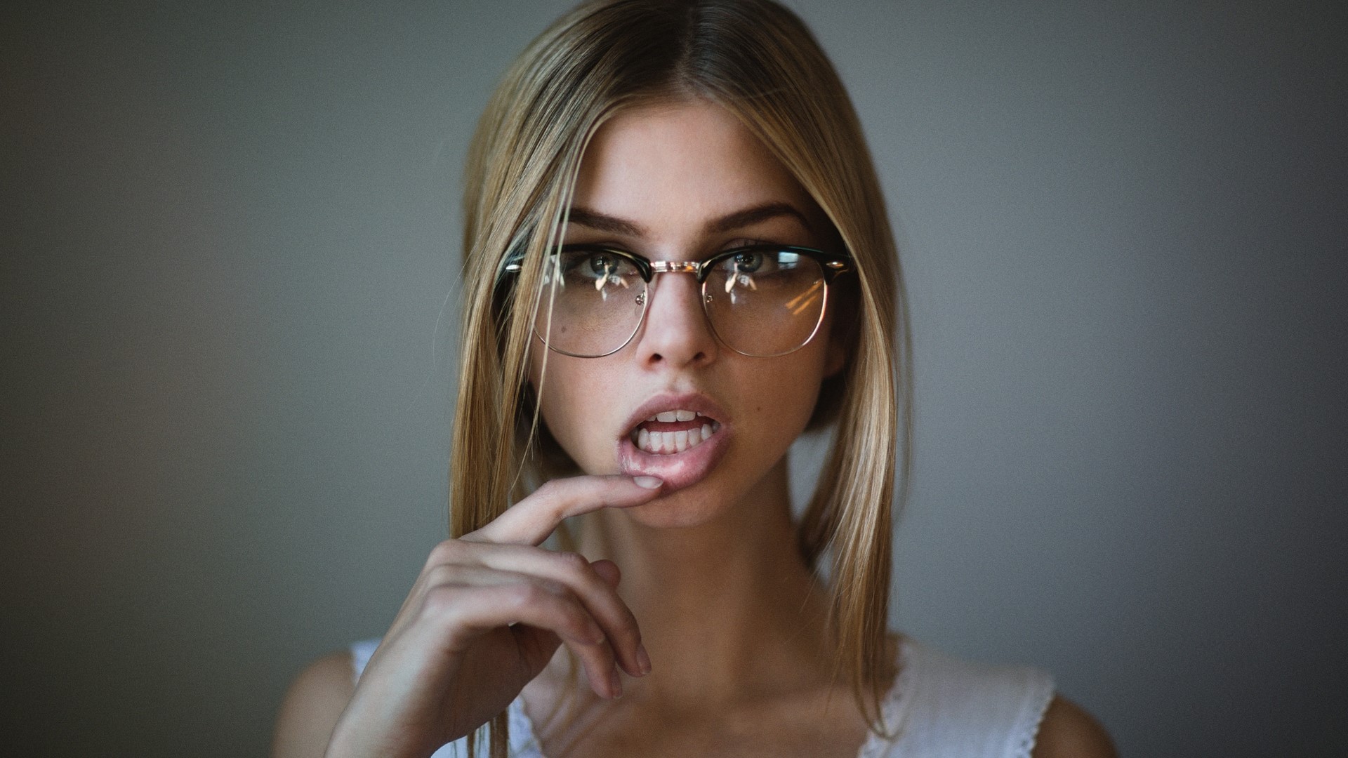 Blonde girl with glasses biting lip HD Wallpaper