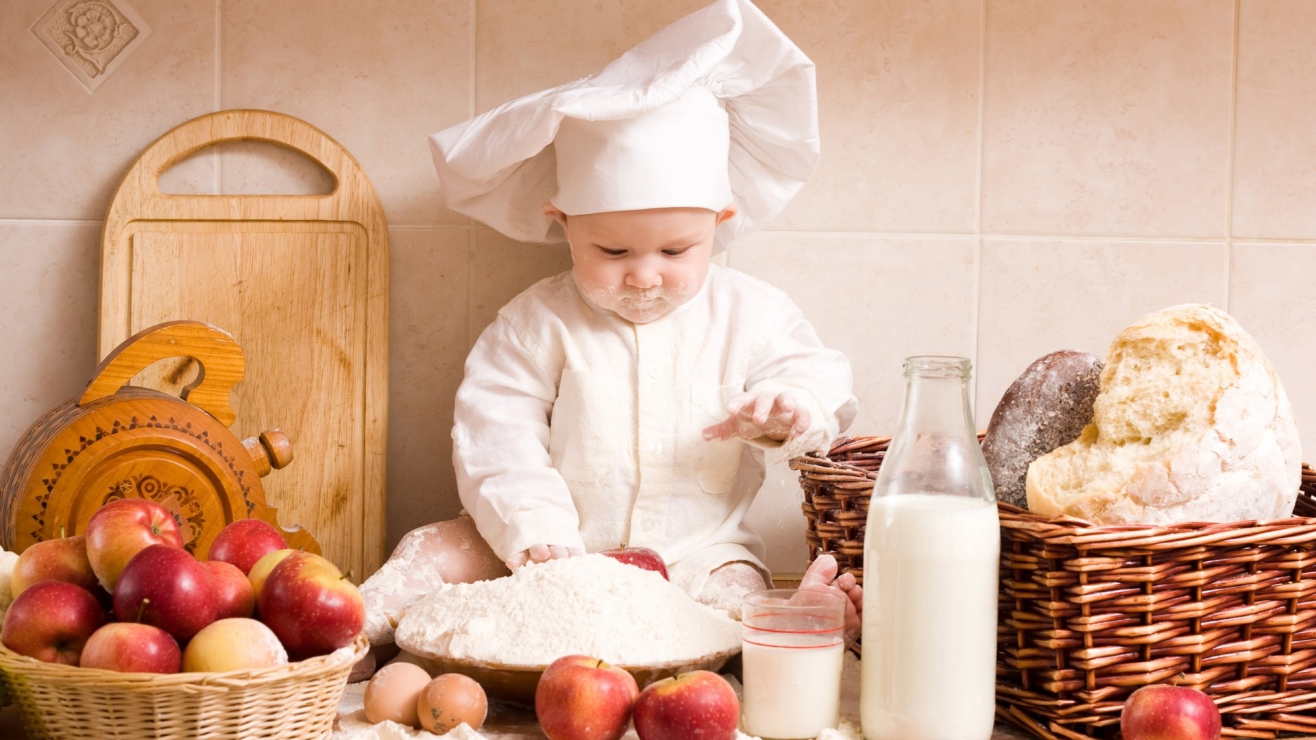 Cute baby chef covered in flour with baking ingredients HD Wallpaper