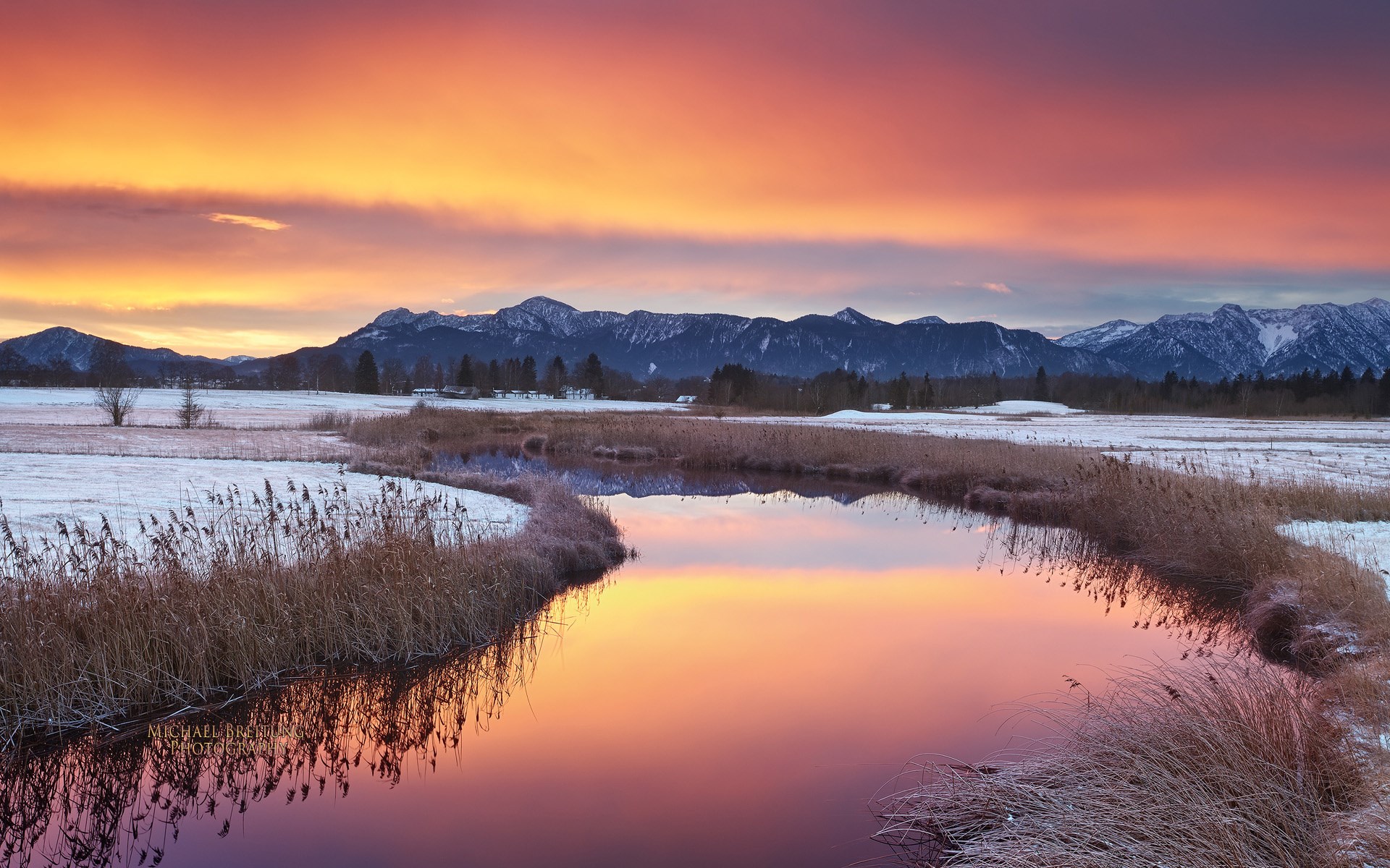Winter sunset over a snowy landscape with mountains and a river HD Wallpaper