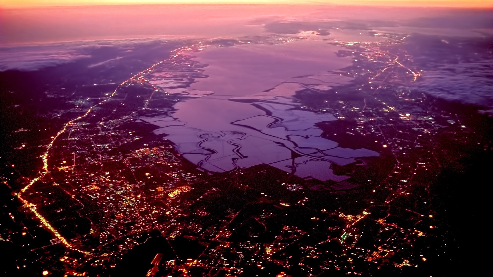 Aerial view of illuminated coastline at sunset HD Wallpaper