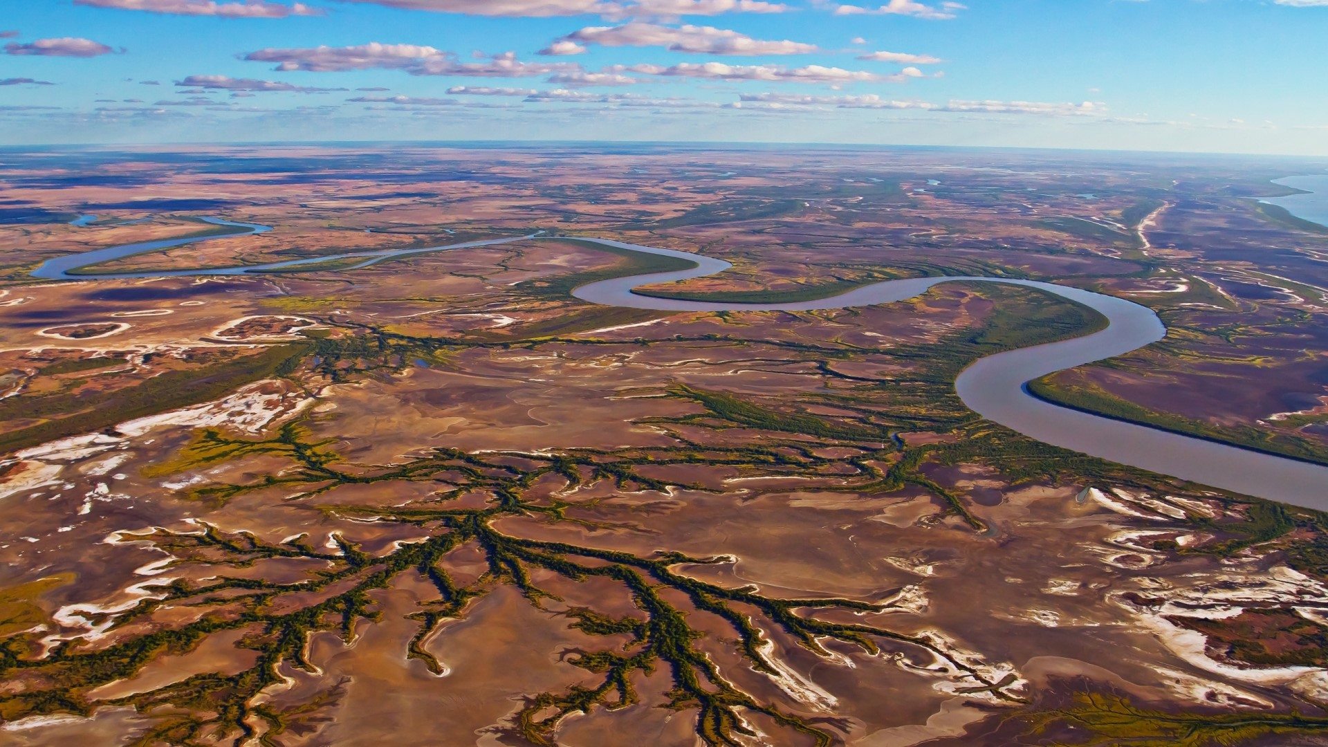 Aerial view of a winding river through a vast landscape HD Wallpaper