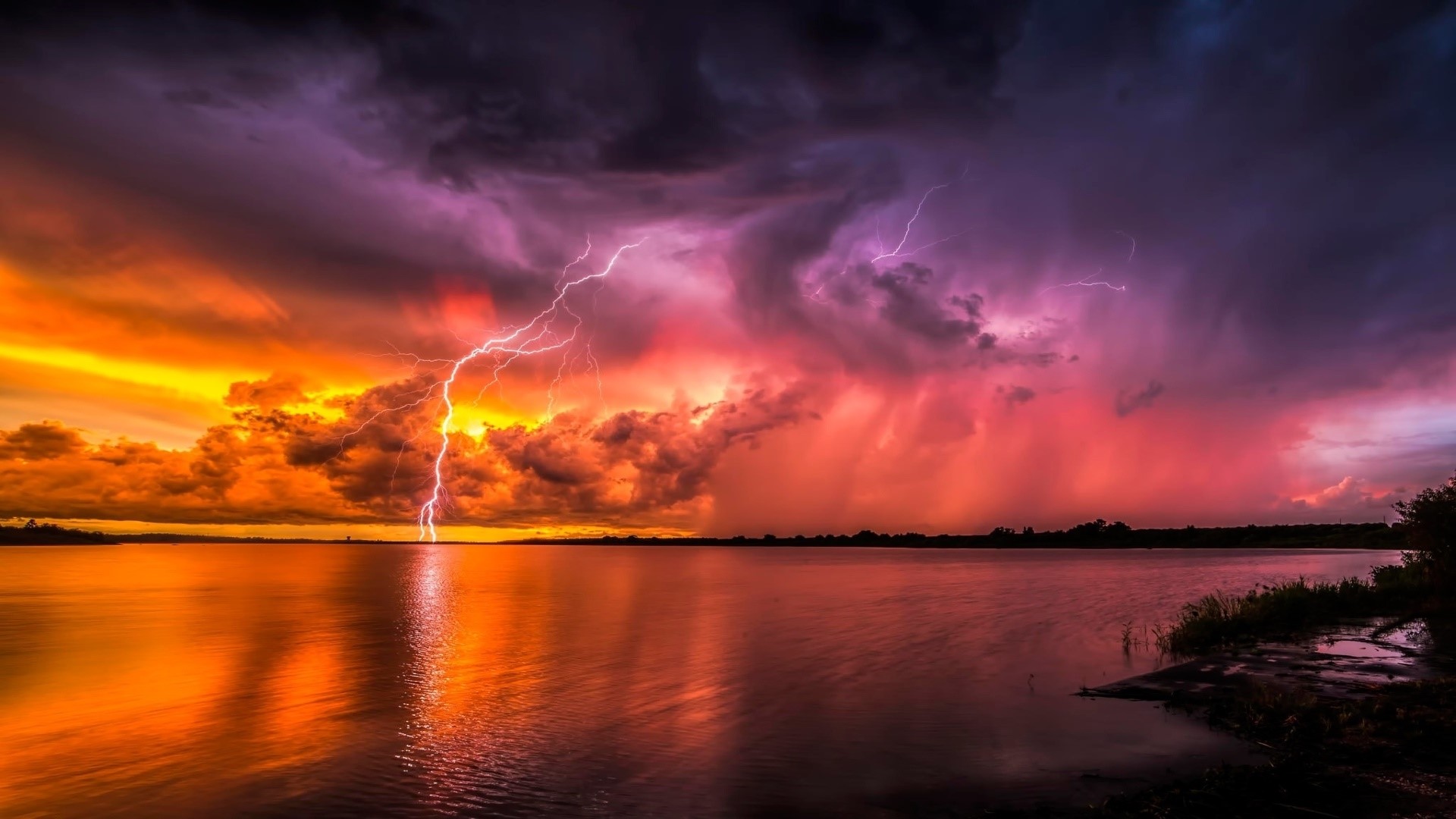 Lightning strikes over a lake at sunset HD Wallpaper