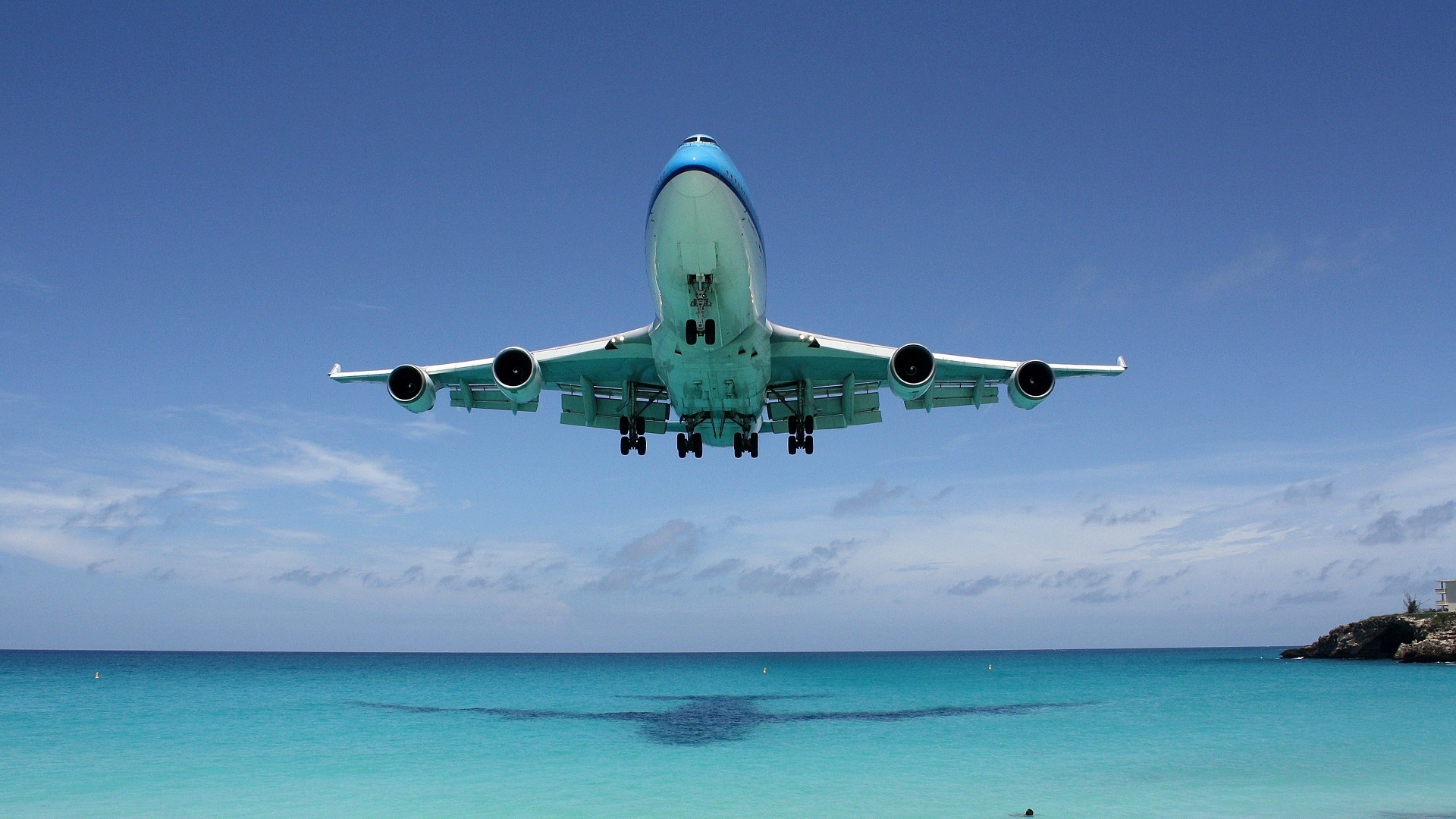 Airplane landing over a tropical ocean HD Wallpaper