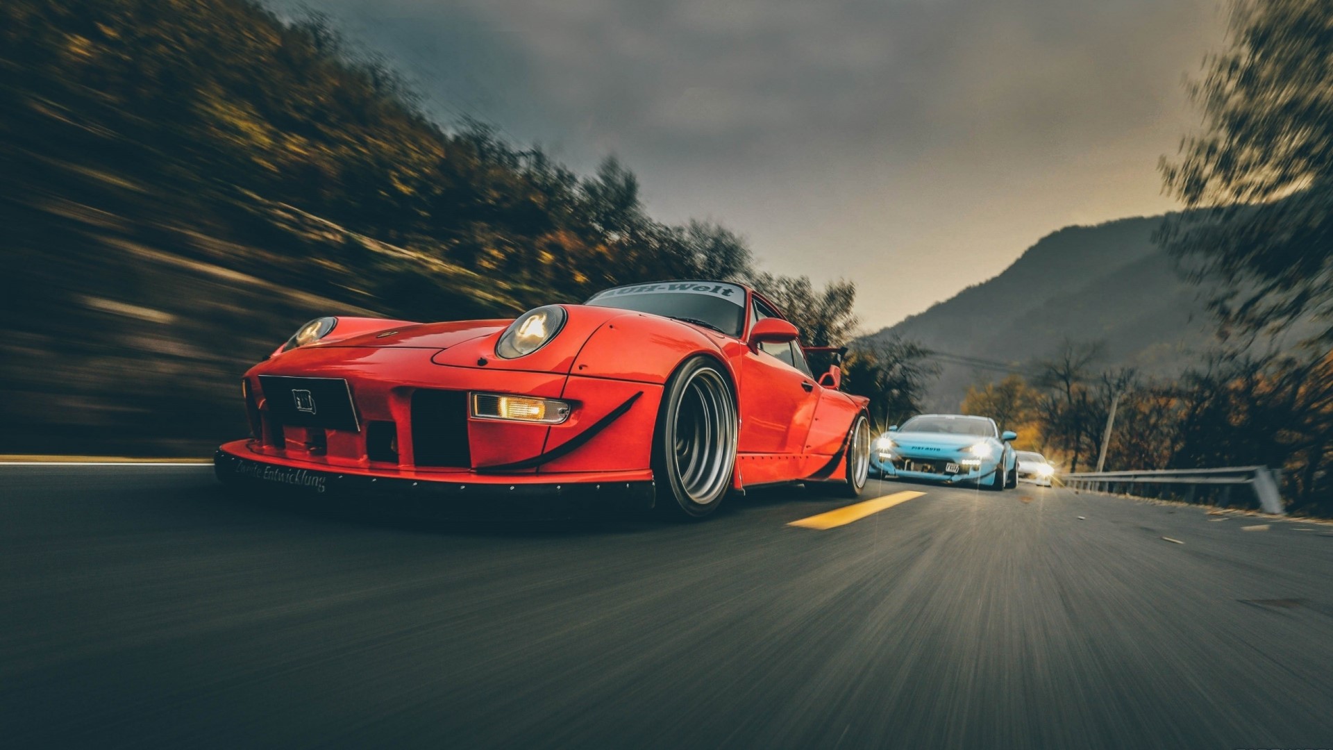 Red Porsche 911 GT3 and blue Porsche on a road HD Wallpaper