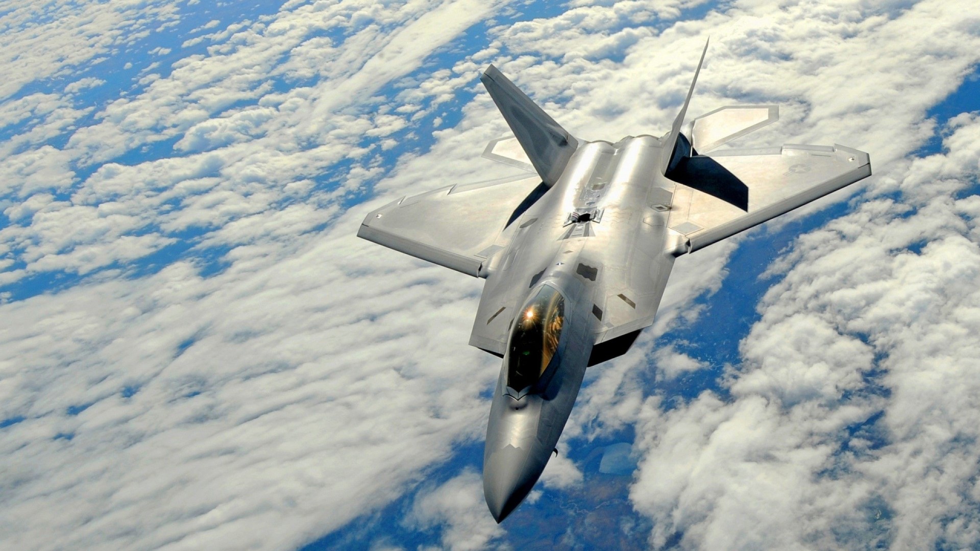 F-22 Raptor fighter jet flying above clouds HD Wallpaper