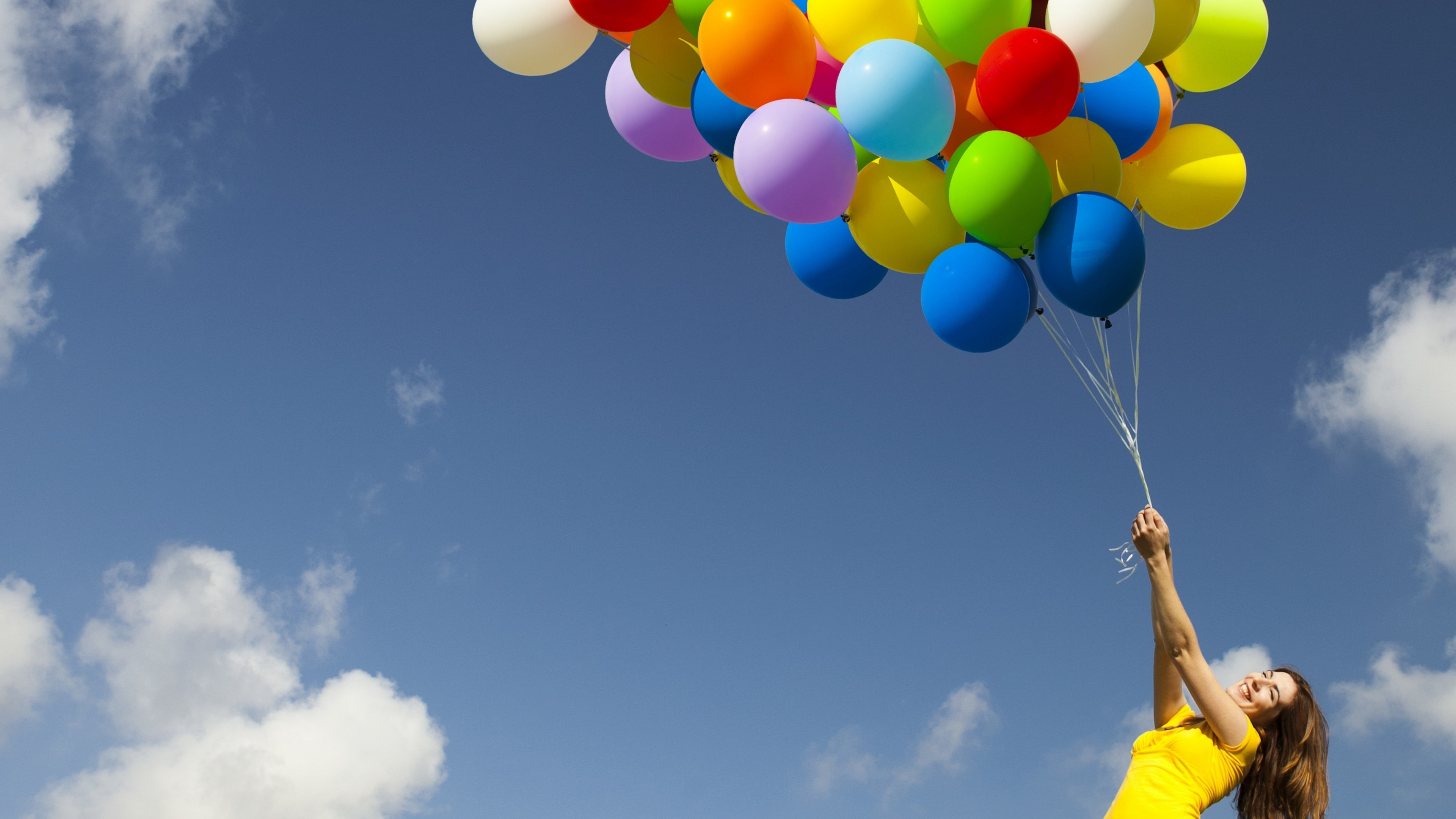 Woman holding balloons against blue sky HD Wallpaper