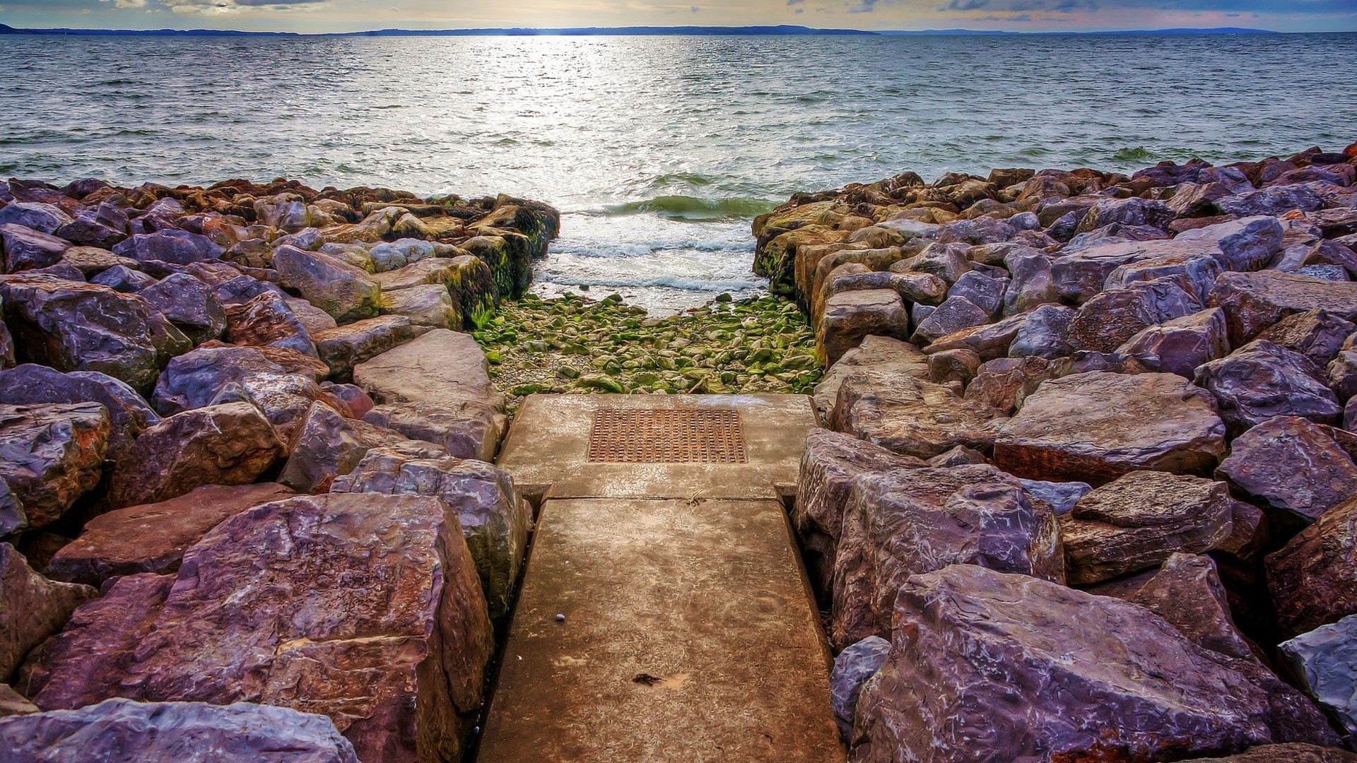Rocky beach with a path to the sea HD Wallpaper