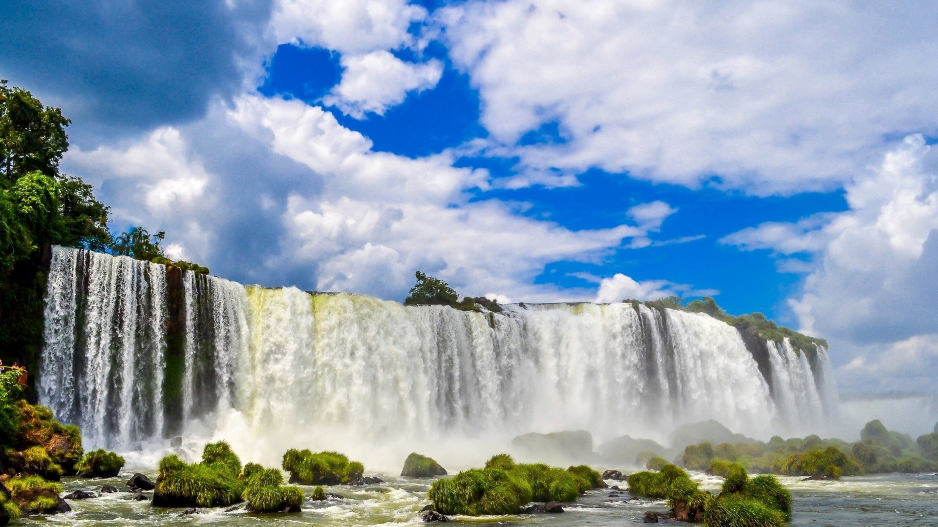 Iguazu Falls under a cloudy blue sky HD Wallpaper