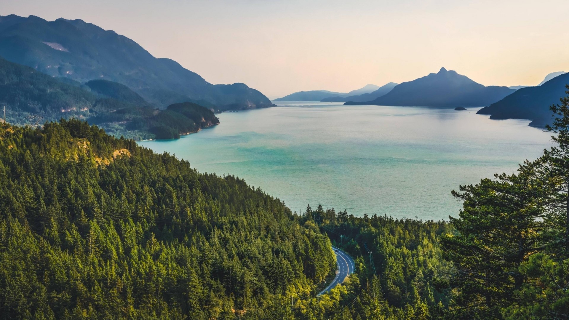 Scenic mountain lake with winding road HD Wallpaper