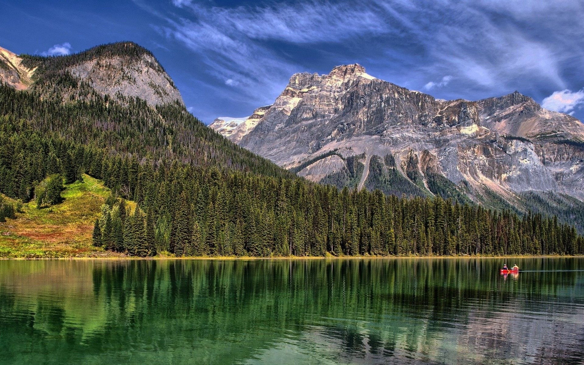 Two people in a red canoe on a lake with mountains HD Wallpaper