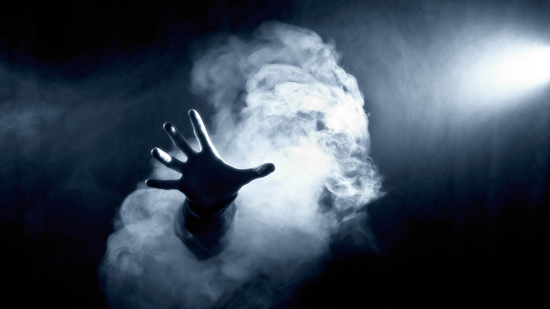 Hand emerging from white smoke with spotlight HD Wallpaper