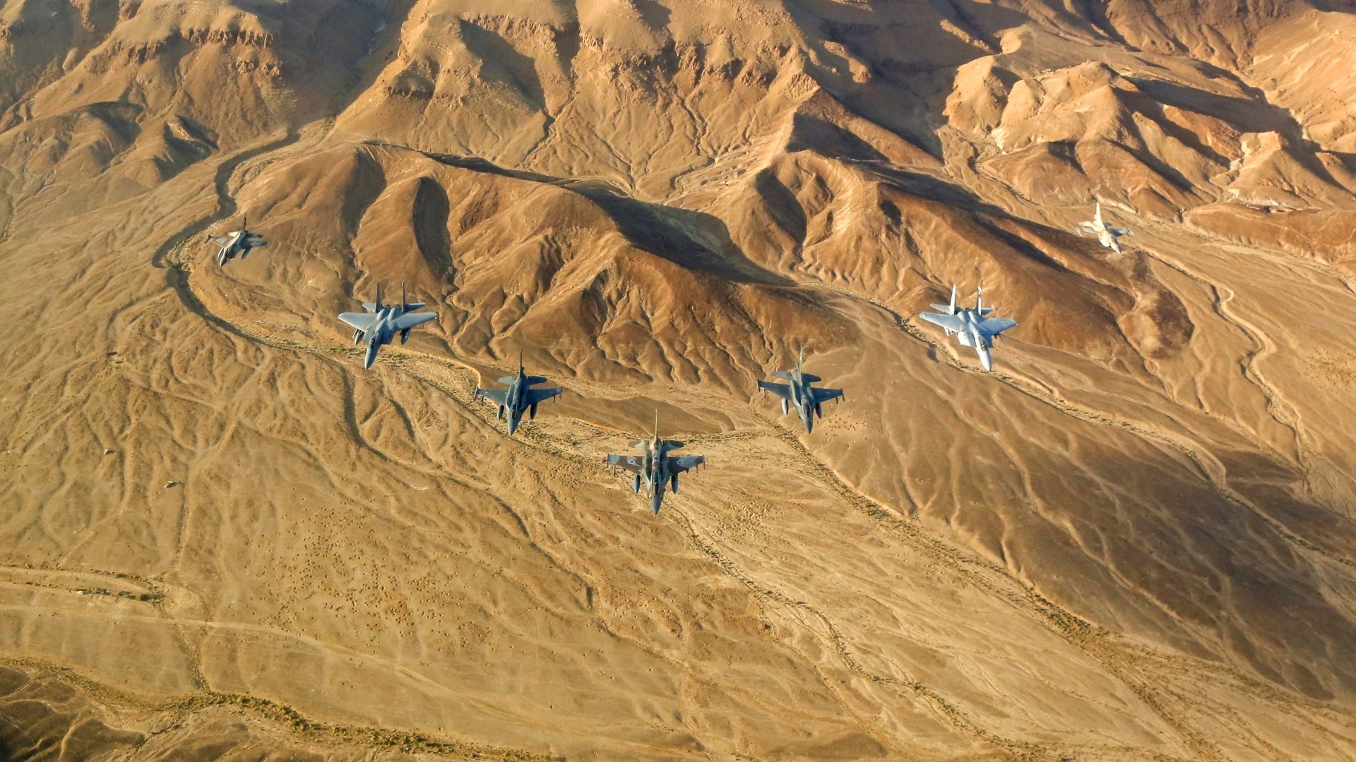 Israeli Air Force F-15 Eagles flying over desert terrain HD Wallpaper