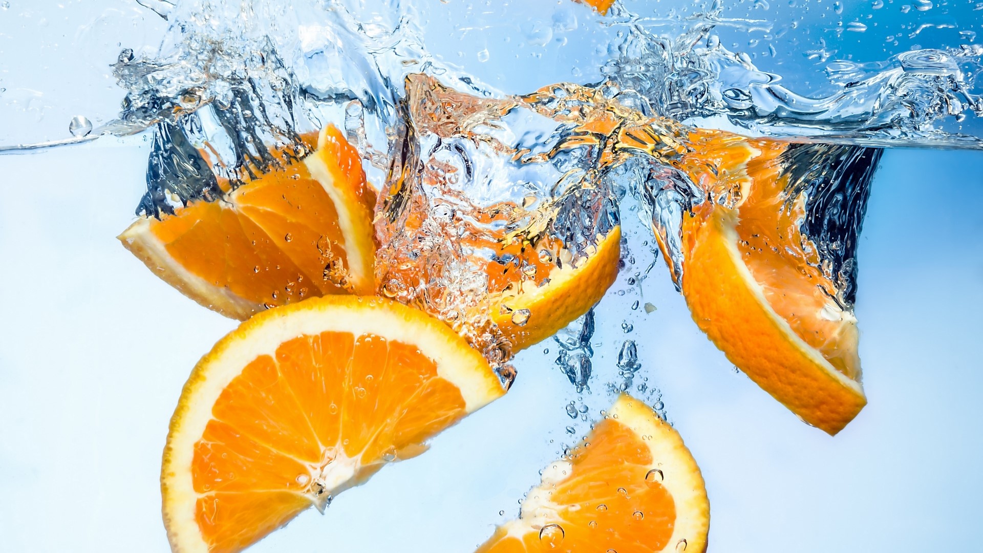 Orange Slices Splashing in Water HD Wallpaper