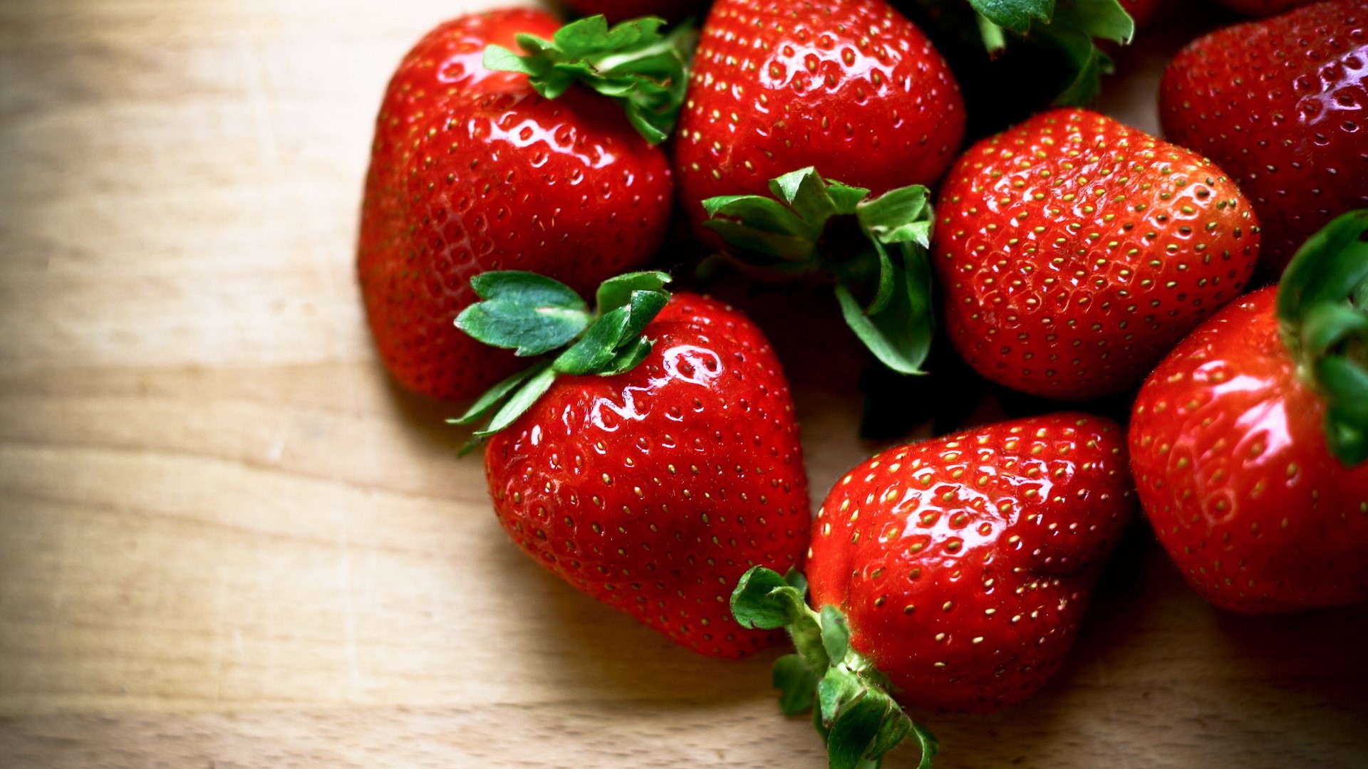 Close-up of fresh strawberries on a wooden surface HD Wallpaper