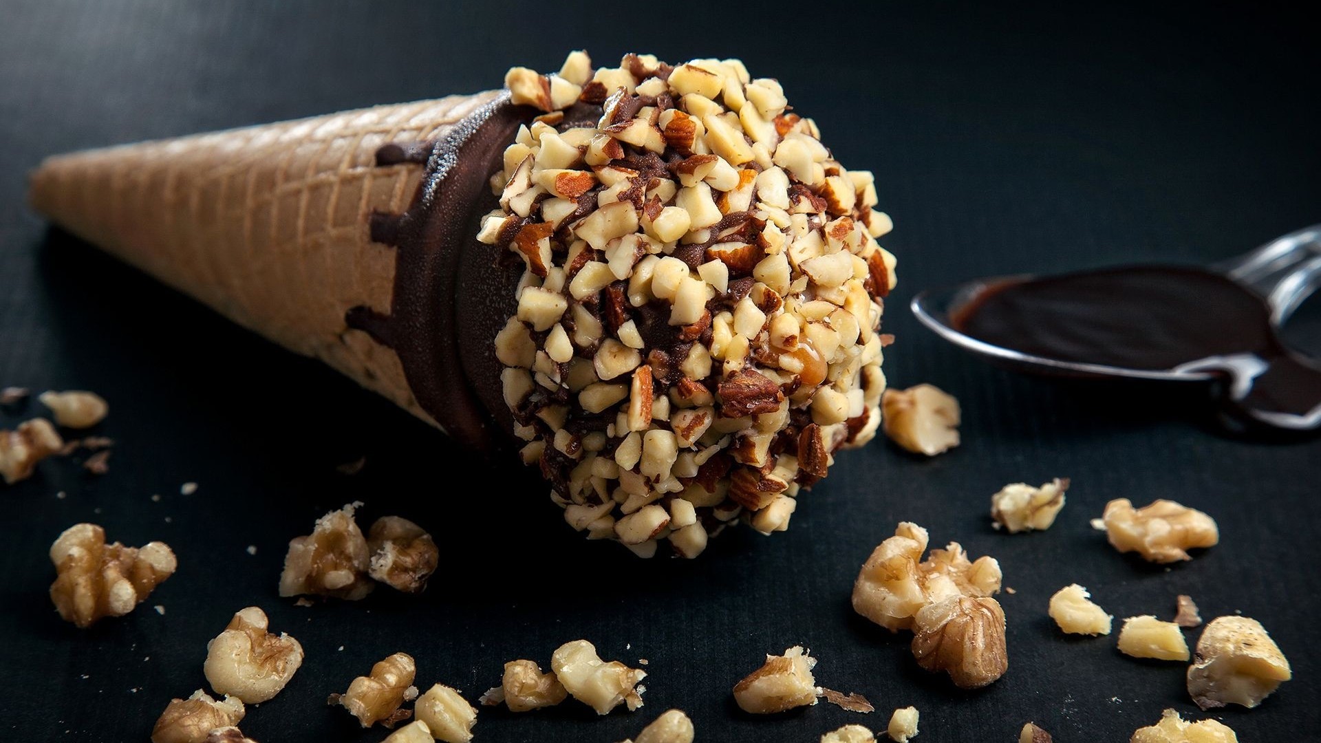 Chocolate ice cream cone with nuts and chocolate sauce HD Wallpaper