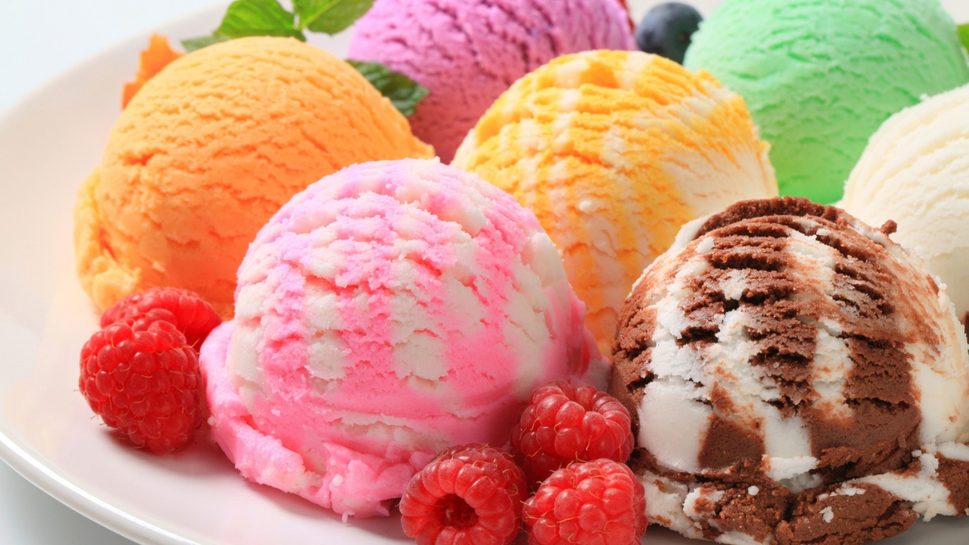 Assortment of colorful ice cream scoops with raspberries HD Wallpaper