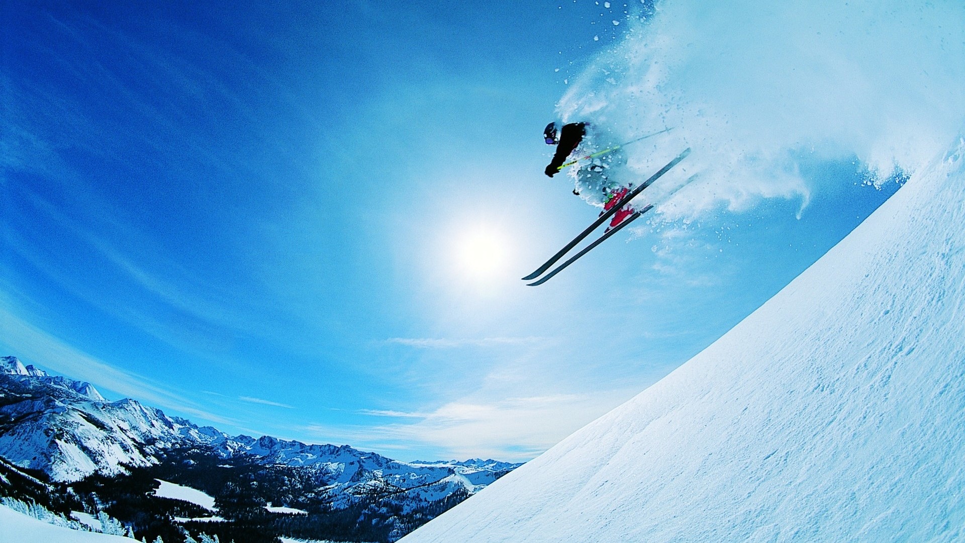Skier jumping in the air with snow spray HD Wallpaper